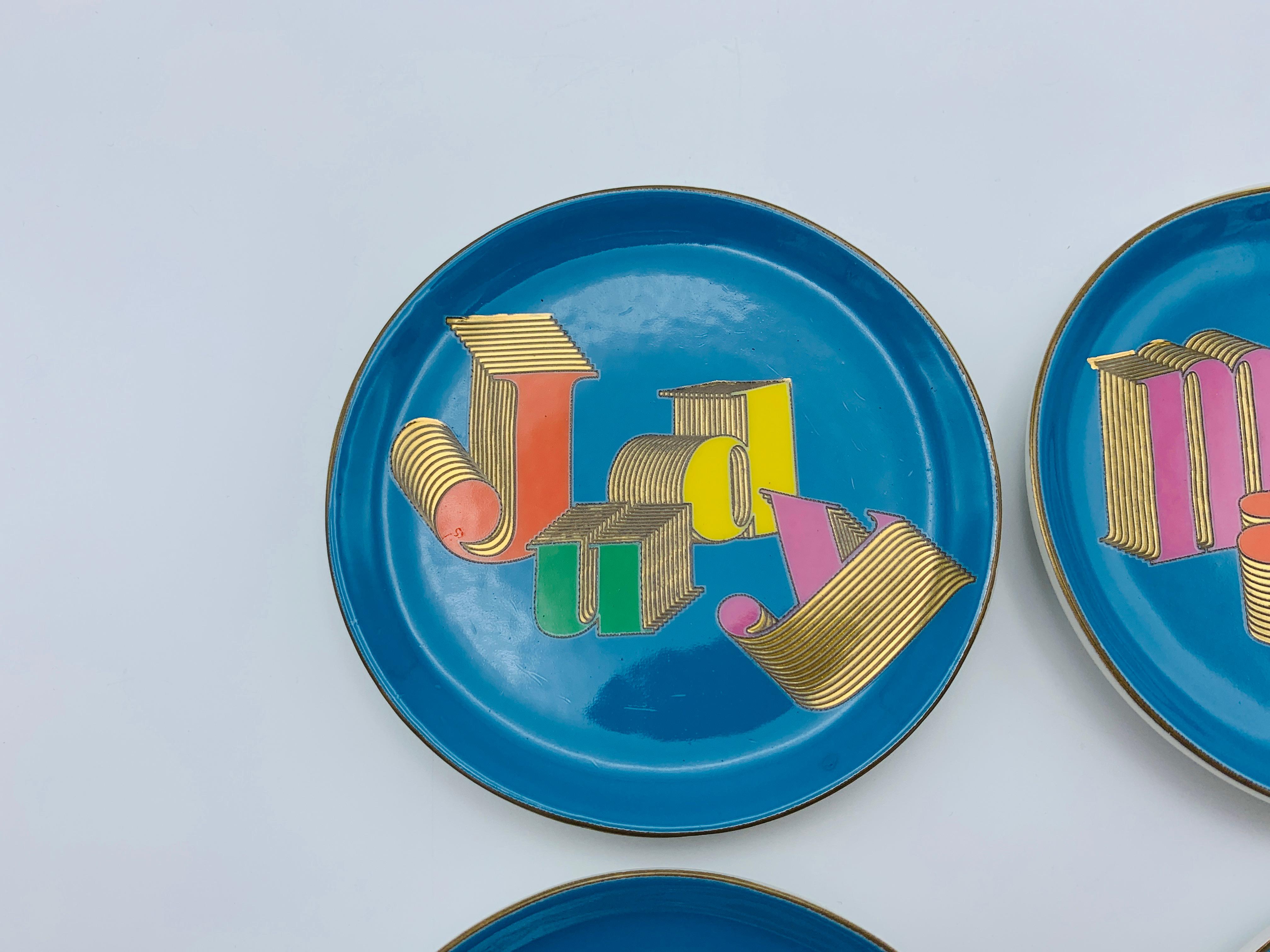 Listed is a fabulous, set of 4, Jonathan Adler porcelain coasters. The set includes all four 'Icons': Judy, Mary, Nancy, and Barbara. Each coaster has colorful typography, 24-karat gold along the edges and measures 4