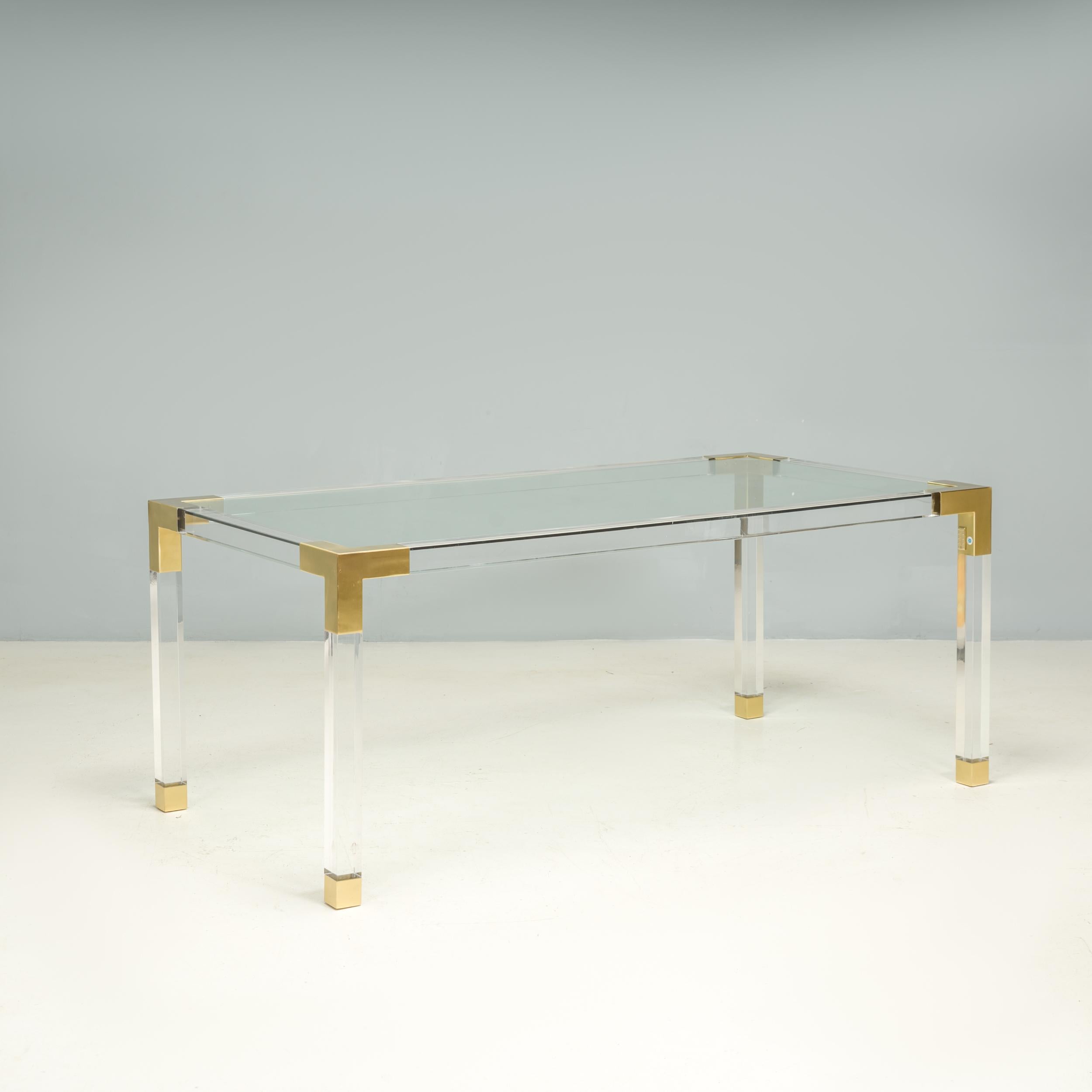 Designed by Jonathan Adler, this contemporary Jacques dining table has an elegant mid century aesthetic. 

Constructed from clear acrylic, the large rectangular dining table features brushed brass corners and feet.

Despite the size, the clear
