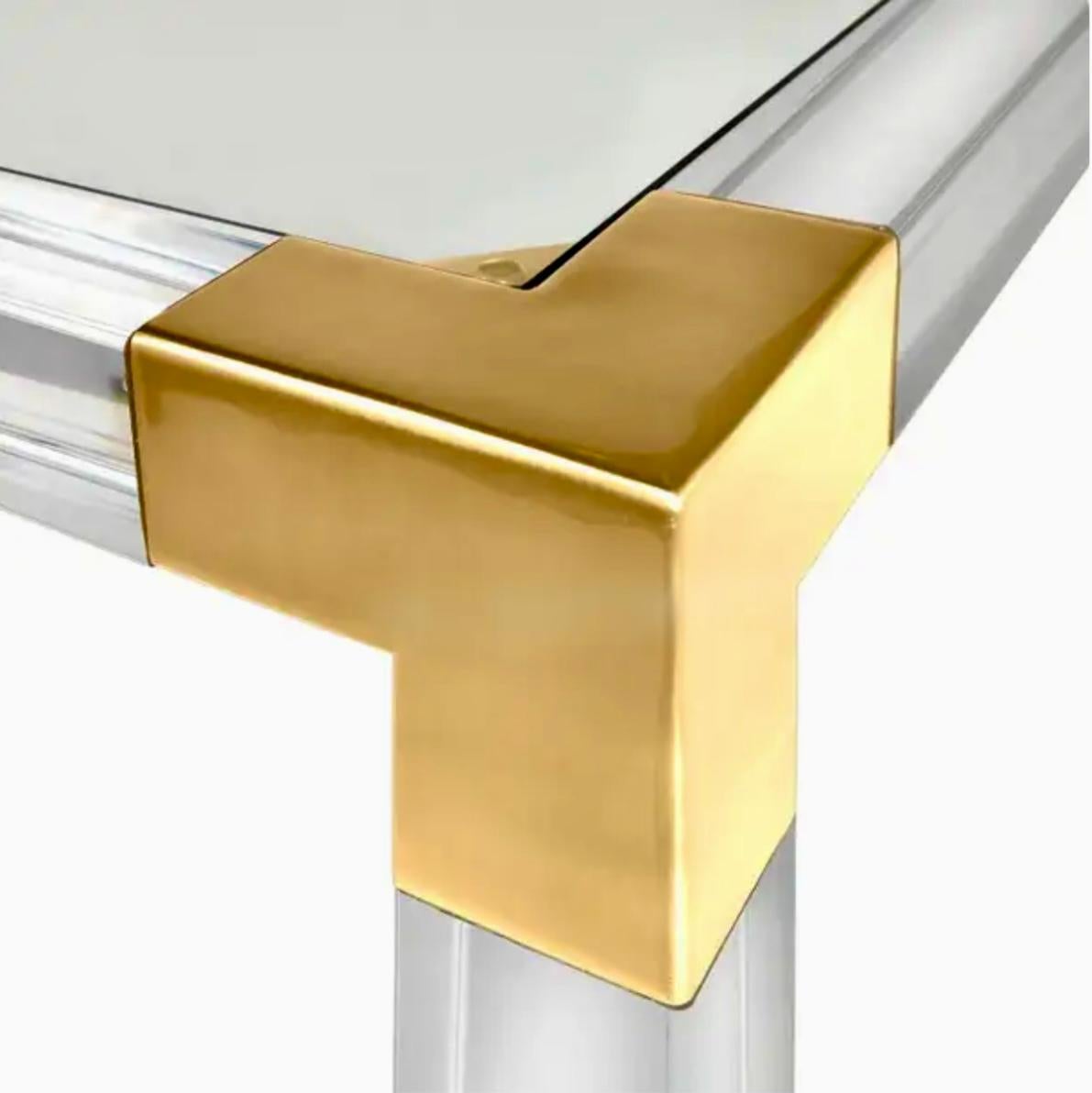 The perfect blend of simplicity and glamour, modern and traditional. Luxe clear acrylic with brushed brass accents and fitted with a low glass shelf for baubles or books. This Jonathan Adler Jacques Console works perfectly behind a sofa or looks fab