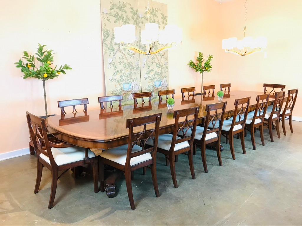 Impressive Regency style triple pedestal dining table with two self-storing leaves. The heavily carved pedestals with acanthus details set on palmettes to the base.
      
