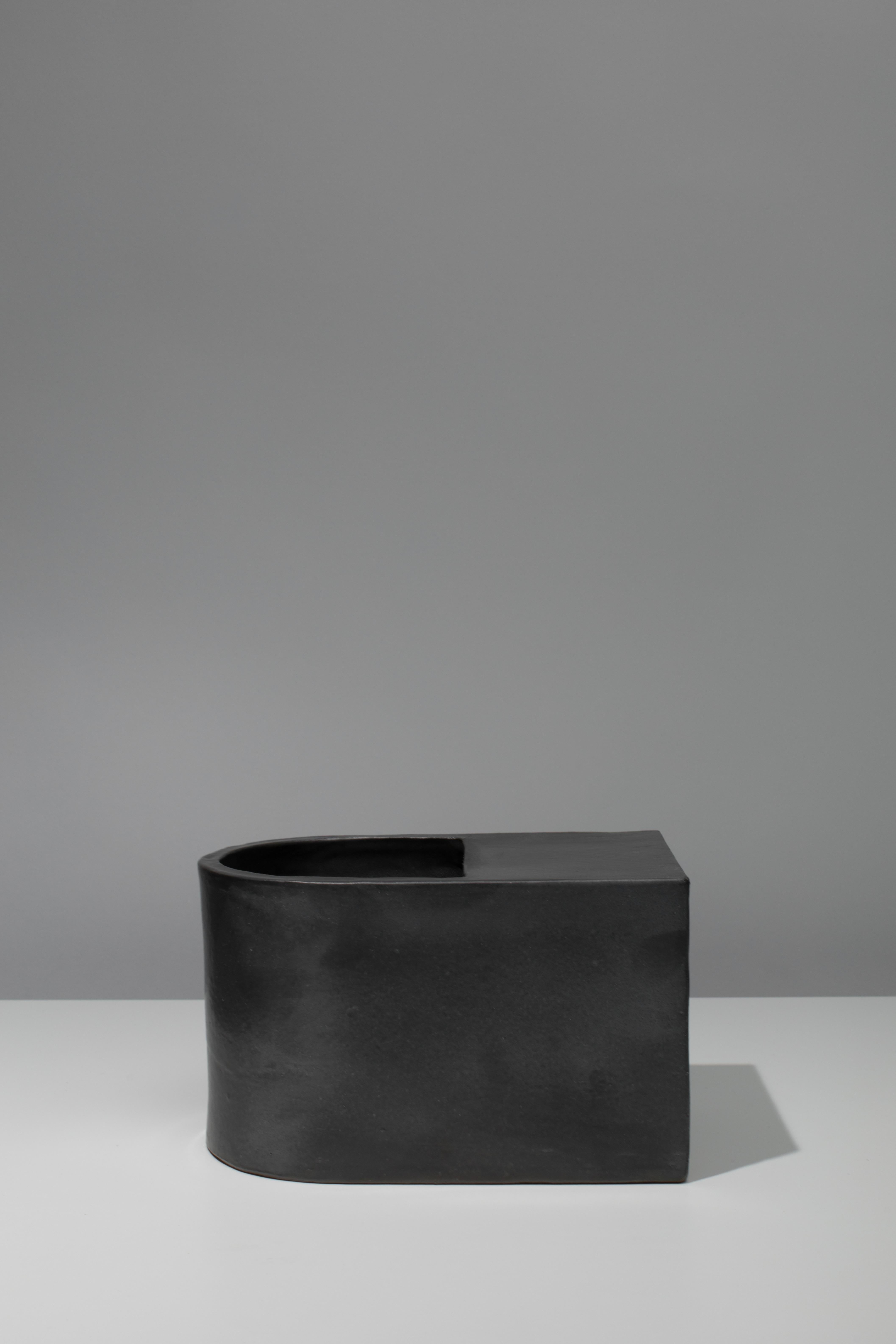 Wheel-thrown and slab-built ceramic vessel with black coppered glaze. Marked with an engraved bronze label to underside: Jonathan Nesci w/ Robert Pulley 18/08. 

Designed by Jonathan Nesci and made in Columbus, Indiana by local ceramist Robert