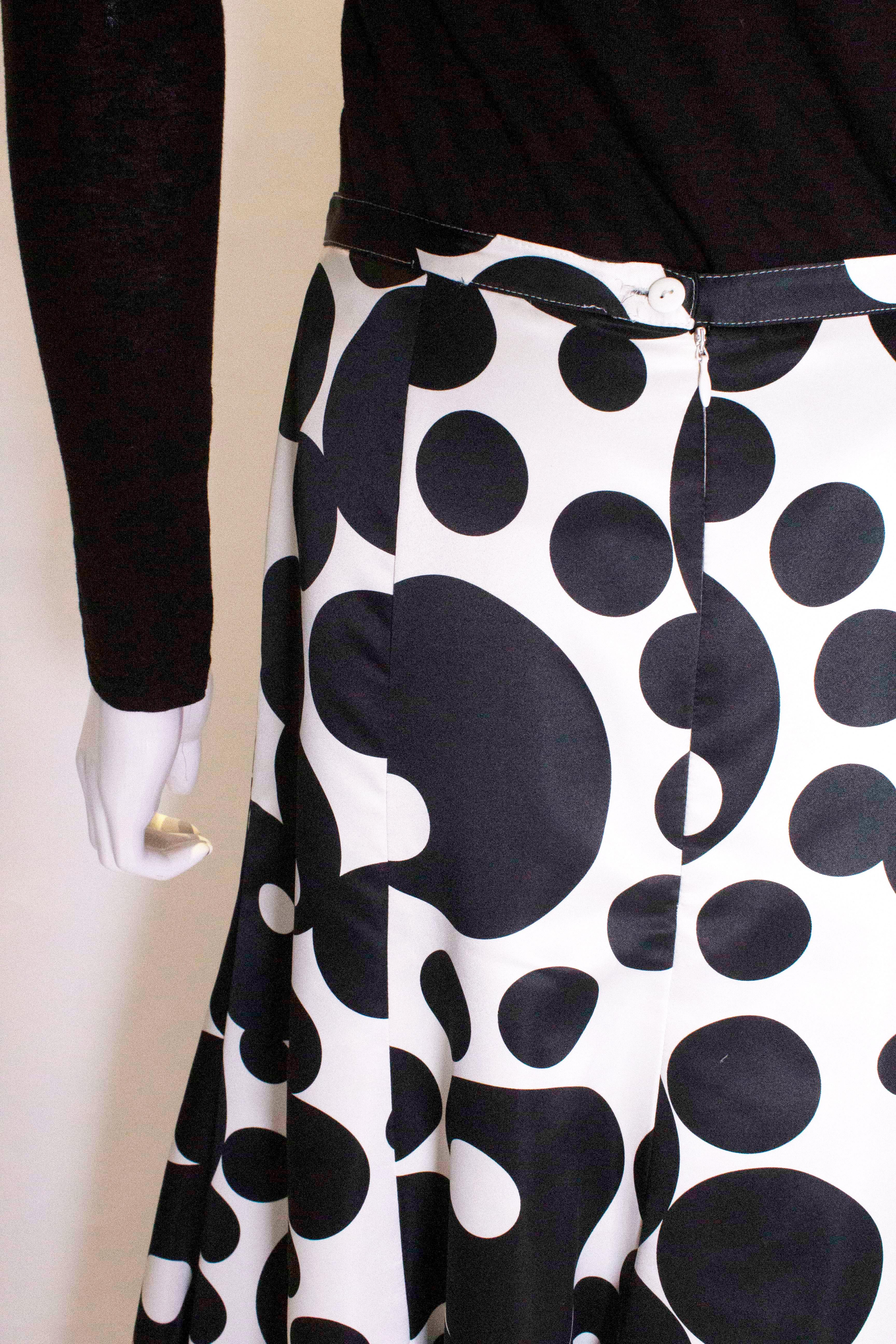 A fun skirt by Jonathan Saunders. The skirt has a white background with black spots of varying sizes. It is panelled and hangs beautifully.  The skirt has a back central zip, is fully lined  and has a net  ruffle at the hem.