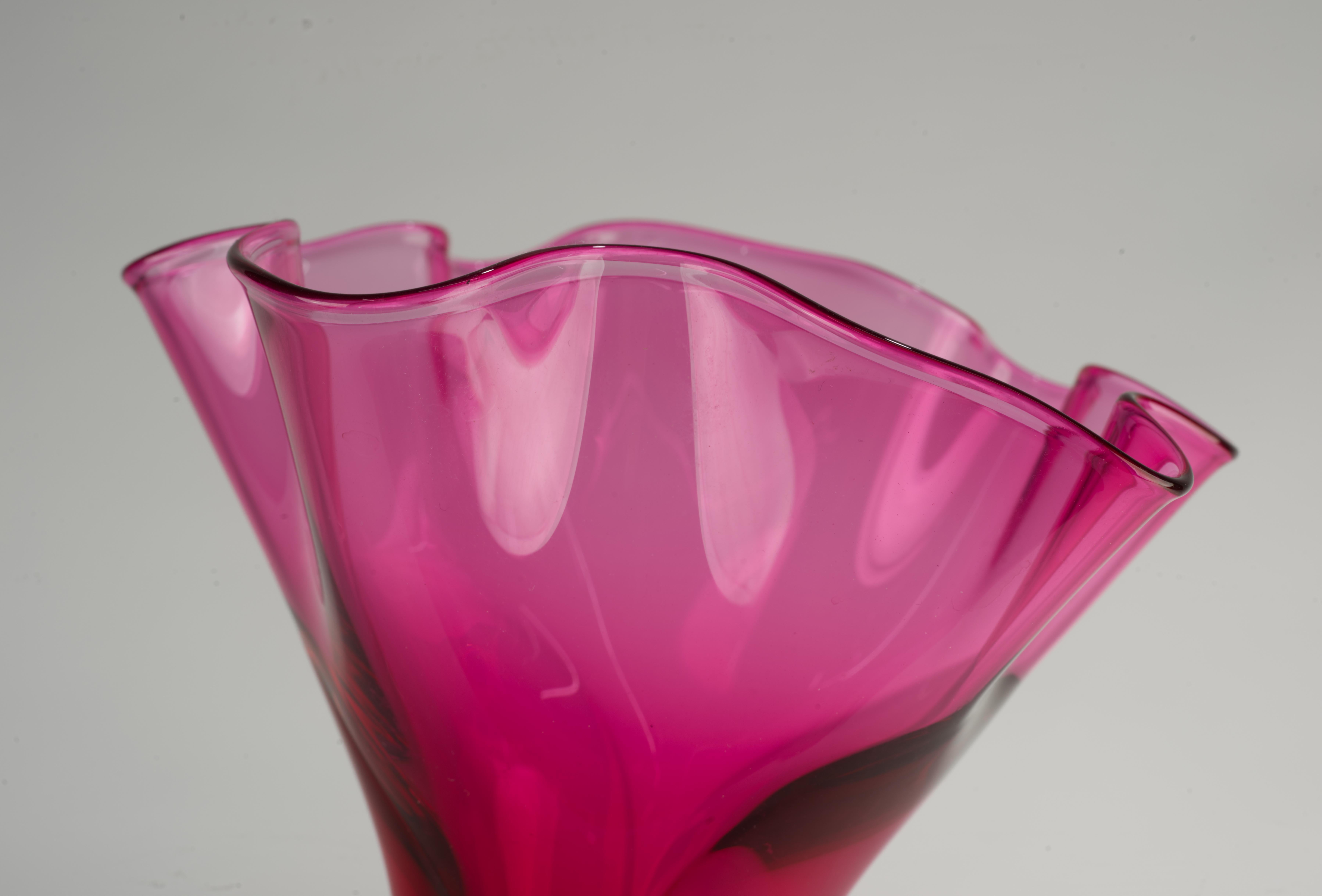 Die mundgeblasene Glasvase mit Blumenaufsatz wurde in einer grafischen Kombination aus dunkelrosa Glas und klarem Glas in der venezianischen Sommerso-Technik hergestellt. Die weiche, sinnliche Form des trompetenförmigen Vasenmundes erzeugt durch die