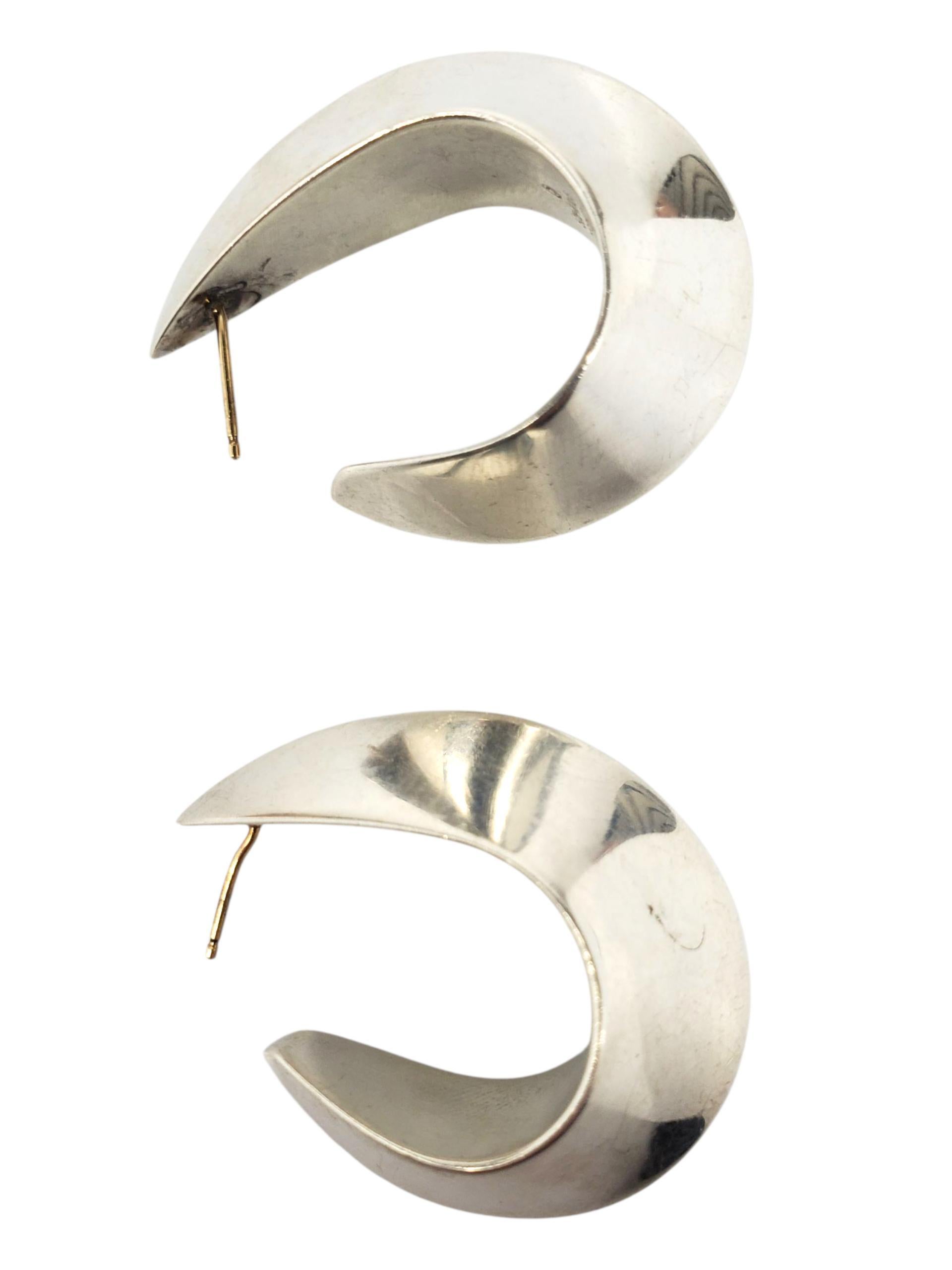 Jondell Boucles d'oreilles en argent sterling Sculptural Hoop Ears -

Ces boucles d'oreilles vintage présentent un anneau sculptural au style moderniste, réalisé en argent sterling hautement poli et marqué Jondell Spain 925.
*Les dossiers ne sont
