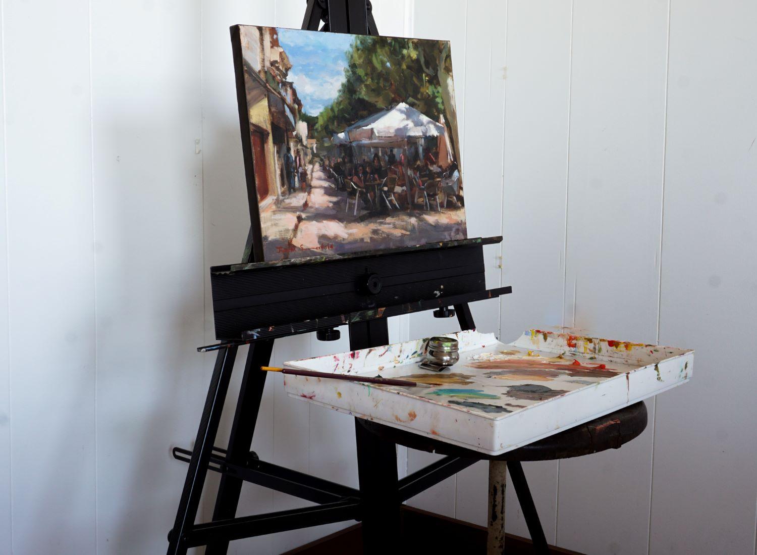 <p>Artist Comments<br />The cafes of Puente la Reina are lively before the siesta. Sunlight filters through lush green trees, casting dappled shadows across a bustling sidewalk. Warm, earthy tones and loose brushstrokes capture the charm and