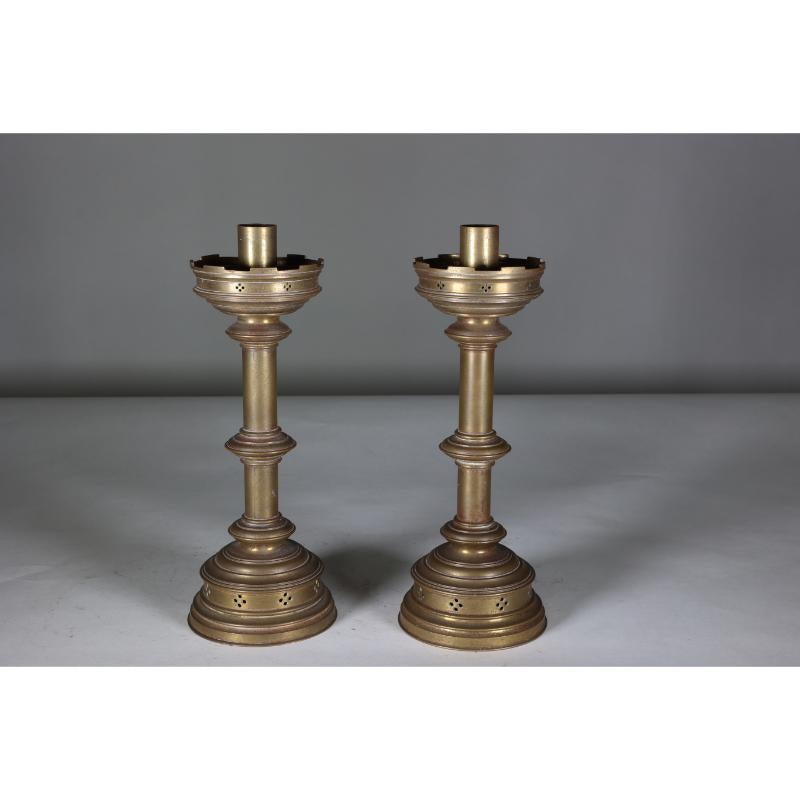 Jones and Willis. A pair of Gothic Revival heavy brass castellated candlesticks with tiny pierced decorations.
