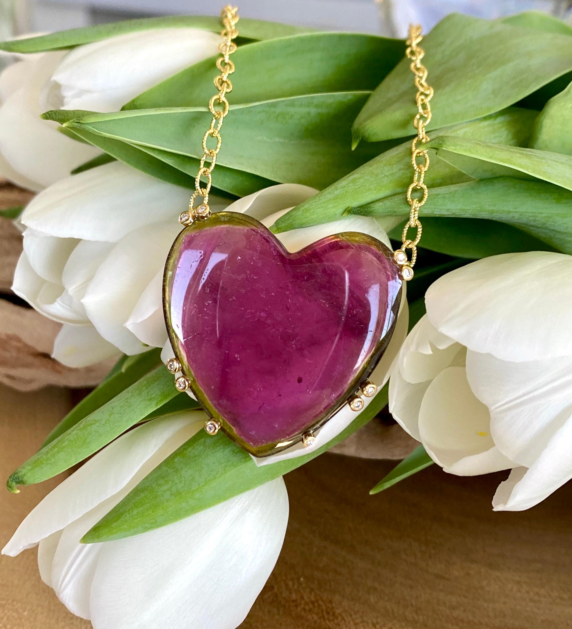 A pendant necklace of a heart shaped watermelon tourmaline with diamond accents, handcrafted in 18 karat yellow gold with an 18 inch chain of 14 karat yellow gold.

This beautiful one-of-a-kind watermelon tourmaline pendant with diamond accents,