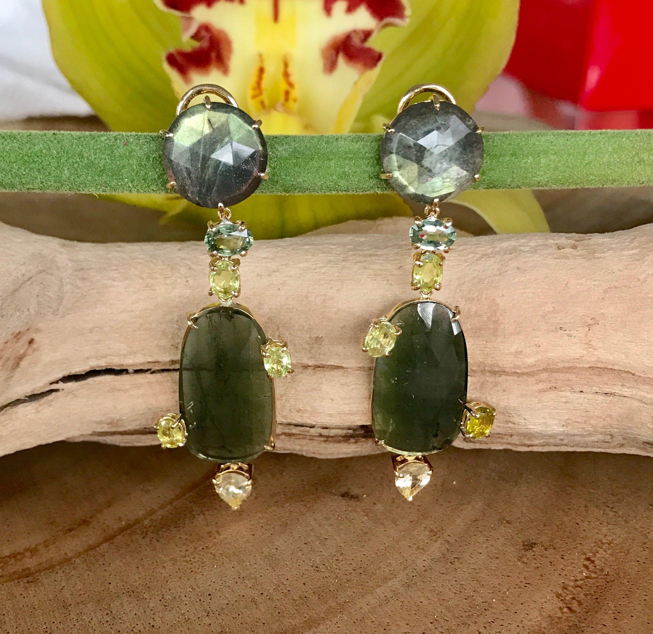 Joon Han whimsical and fun one-of-a-kind earrings of labradorites and fancy rose cut green tourmalines, with faceted sapphire and chrysoberyl accents. These shimmery green drop dangle earrings are handcrafted in 18K yellow gold.

Joon Han is a