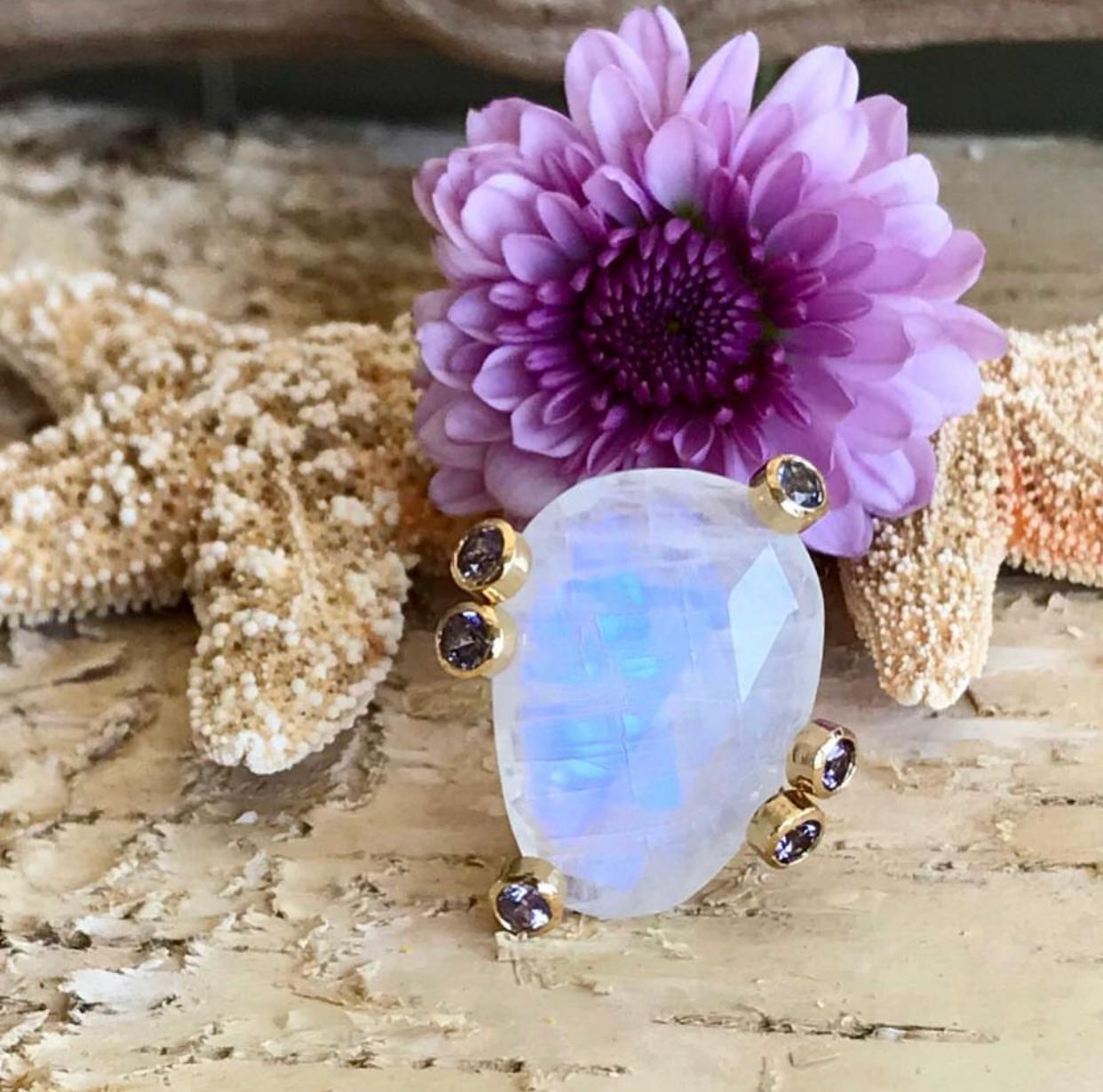 One-of-a-kind fancy shape rainbow moonstone solitaire cocktail ring, accented by sparkling faceted spinels, handcrafted in 18 karat yellow gold.

Perfect for any season, this iridescent rainbow moonstone ring flashes brilliantly with color when it