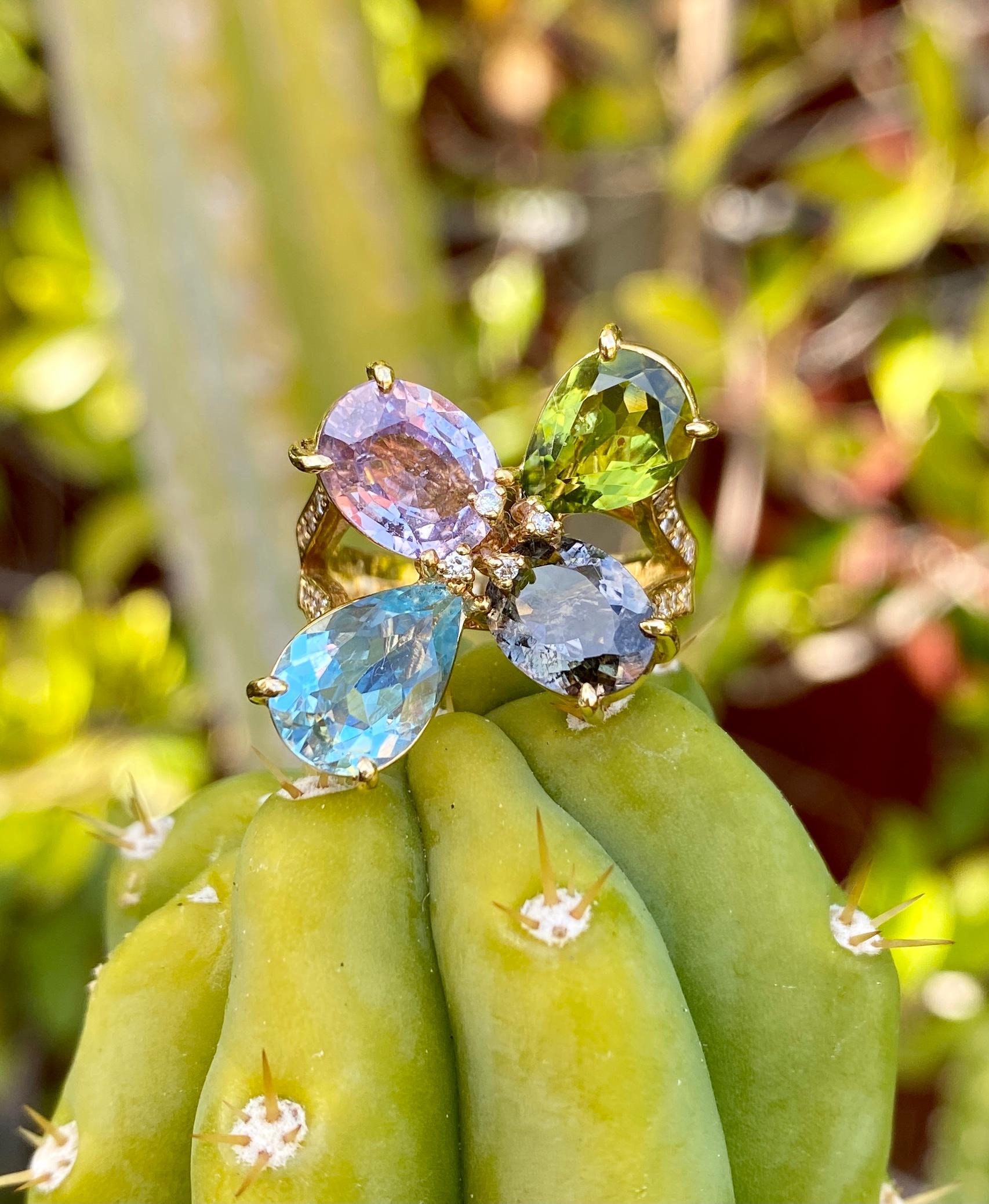 A cluster 4-stone cocktail ring with sapphire, aquamarine, tourmaline, peridot and diamonds, handcrafted in 18 karat yellow gold.

This multigem, one-of-a-kind, asymmetrical cluster ring of sparkling faceted gemstones is very unique and pretty in