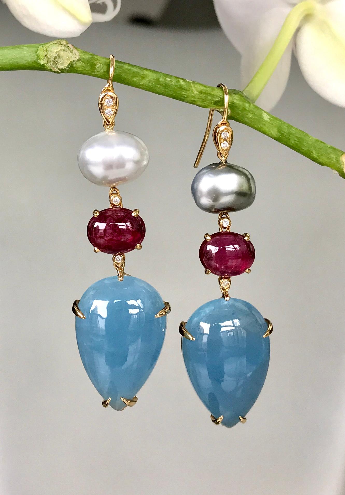One-of-a-kind dangle earrings of South Sea and Tahitian cream and grey keshi pearls, cabochon rubellite tourmalines, fancy cabochon aquamarine drops, and diamonds, handcrafted in 18 karat yellow gold. 2.5 inches or 63 mm length.

These luminescent