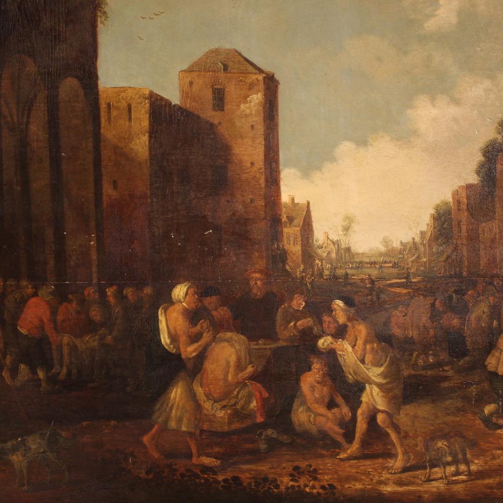 Ein seltenes flämisches Gemälde, signiert und datiert 1646. Dieses Kunstwerk in Öl auf Leinwand zeigt eine wunderbare Genreszene in einer nordischen Stadt, die von einer wimmelnden Menge von Bettlern, Kranken und um Almosen bettelnden Geistlichen
