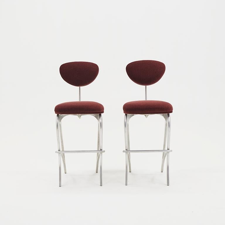 Pair of Hudson bar stools designed by Jordan Mozer, 2019.  Sculptural cast aluminum frames with burgundy / deep red mohair upholstery.  Very good condition with few signs of use.