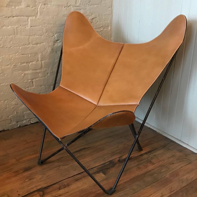 Mid-Century Modern, butterfly chair by Jorge Ferrari-Hardoy for Knoll International features a tan luggage leather cover with a black wrought iron frame.