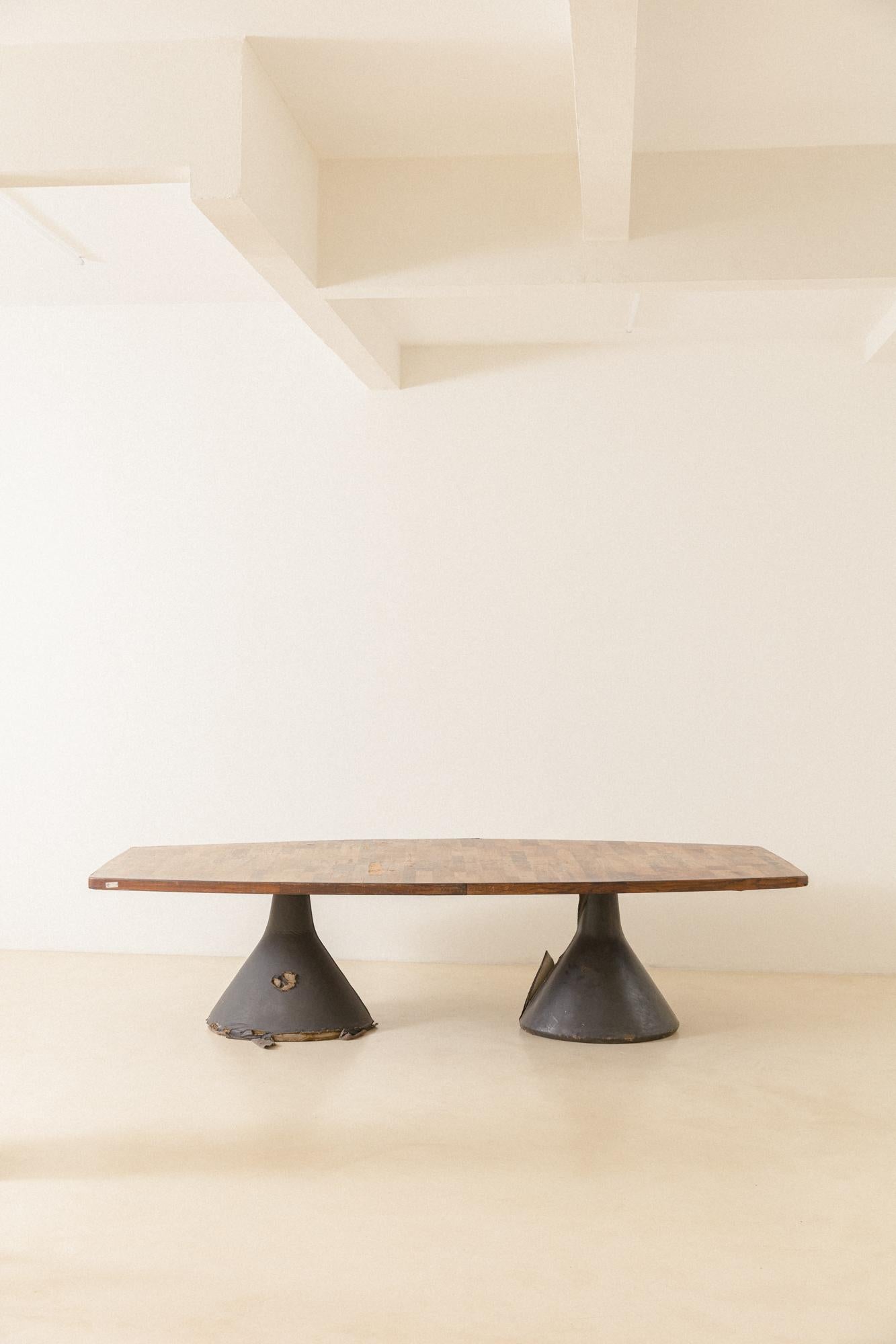 The iconic Guanabara is a table designed by Jorge Zalszupin (1922-2020) in 1959 and produced by his company, L'atelier. A long rosewood patchwork top rests over two concrete bases finished with black leather.

This patchwork solution is present in