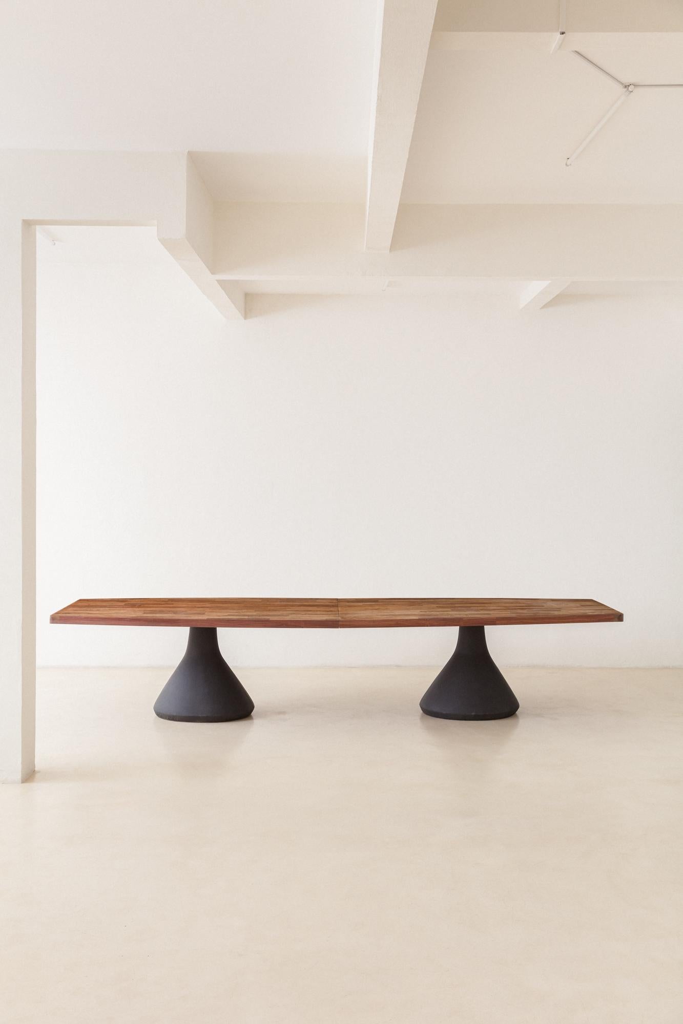 The iconic Guanabara is a table designed by Jorge Zalszupin (1922-2020) in 1959 and produced by his company, L'atelier. A long rosewood patchwork top rests over two concrete bases finished with black leather.

This patchwork solution is present in