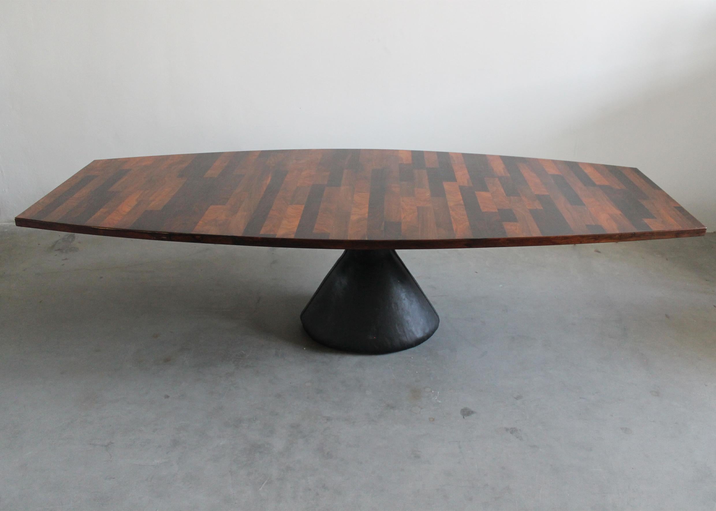 Large Guanabara pedestal conference table with an ovoidal shaped tabletop entirely realized in neroipè and jatoba wood which creates a beautiful patchwork effect (the idea of realizing a patchwork top came from the reuse of the left-over scraps of