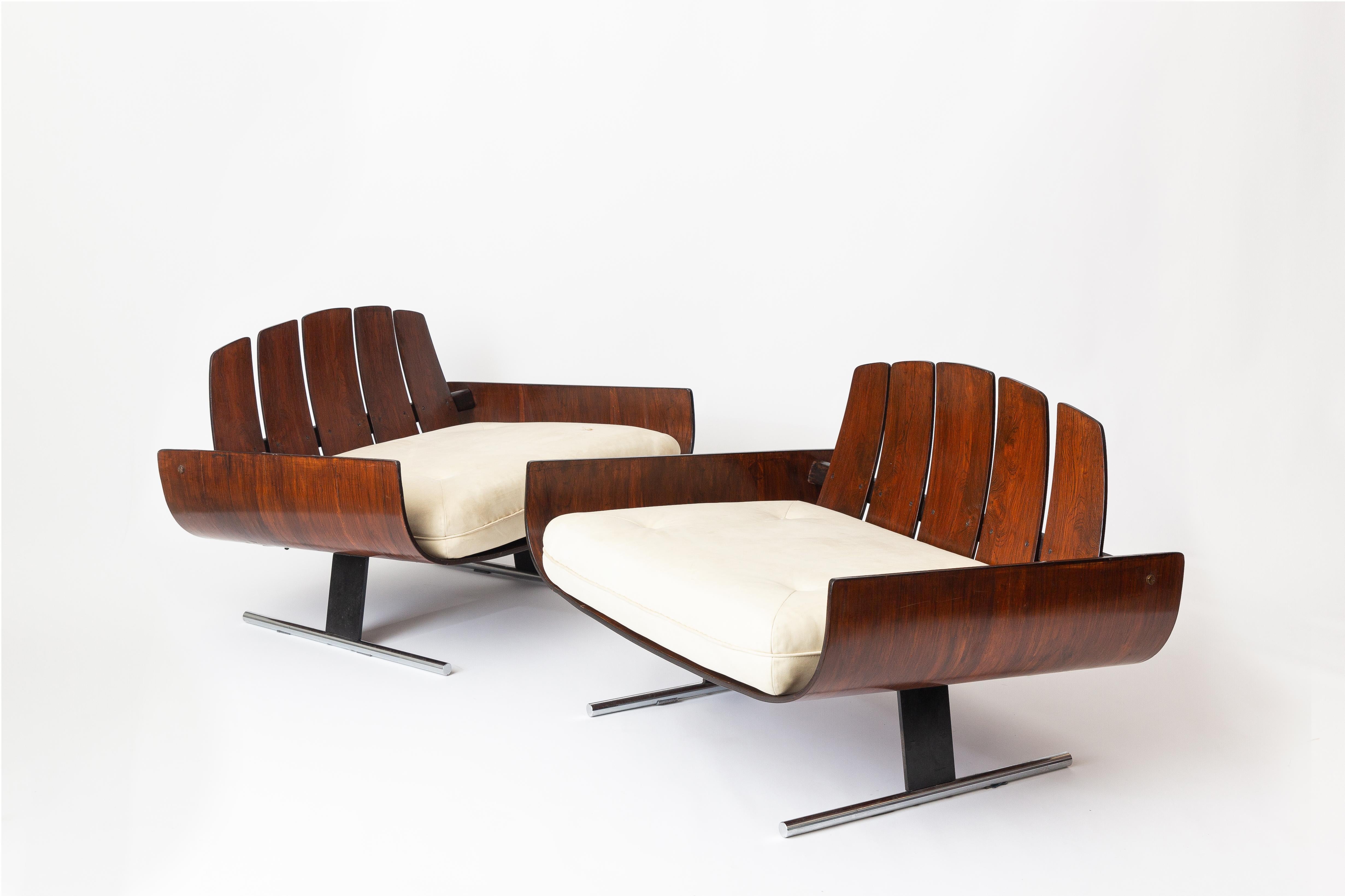 Magnifique paire d'iconiques fauteuils de salon Presidencial du maître du design brésilien Jorge Zalszupin. Produites dans les années 1960, ces chaises de forme unique se caractérisent par un fond en bois incurvé, un dossier à lattes et de longs