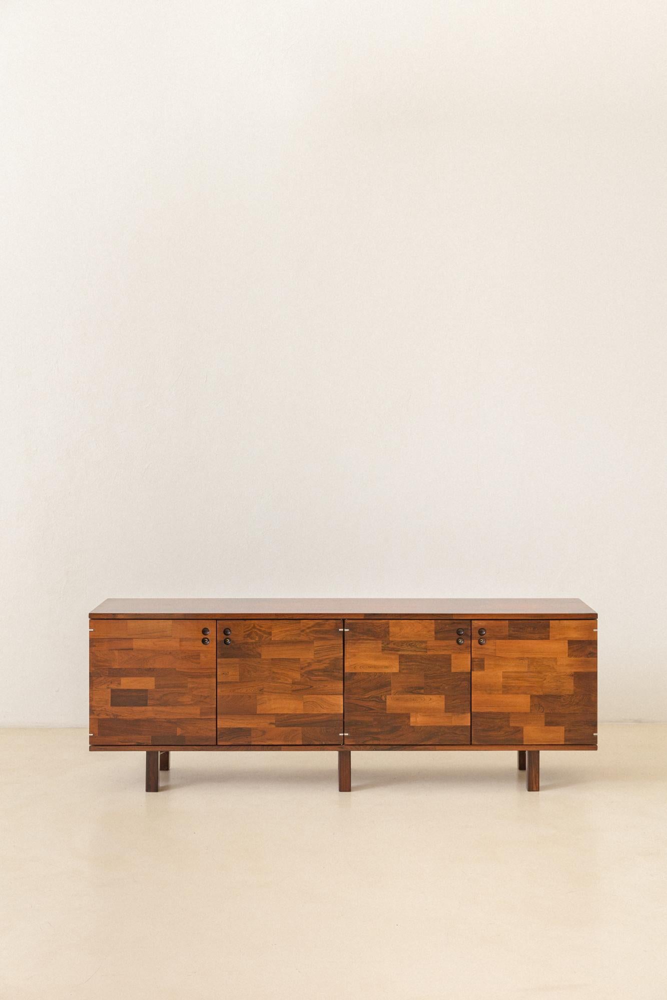 Cette crédence en bois de rose, conçue par Jorge Zalszupin (1922-2020) et fabriquée par L'Atelier dans les années 1960, est une excellente façon d'avoir la diversité des différents tons de bois de rose en une seule pièce.

La pièce est en très bon