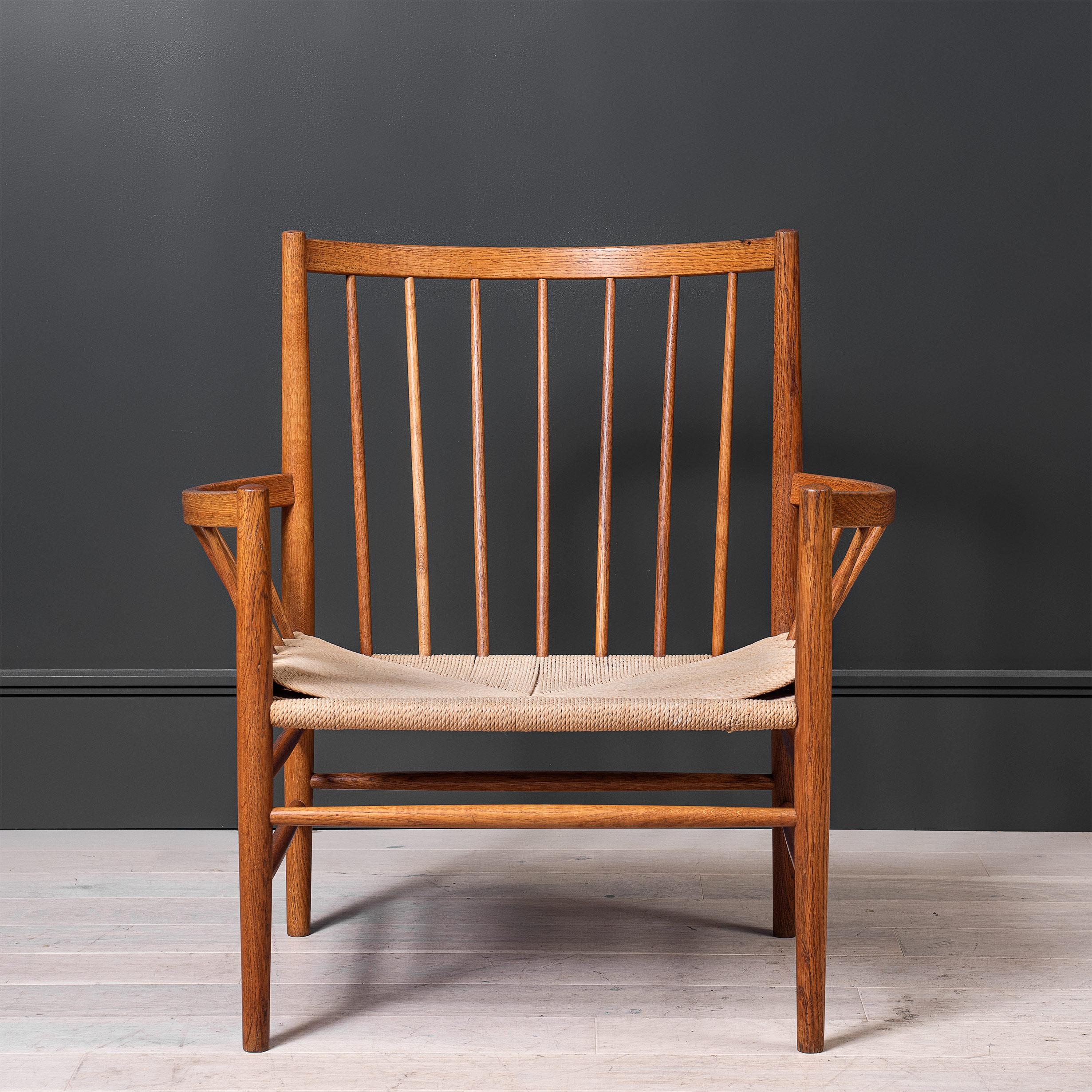 An original Jorgen Baekmark - FDB Møbler’s lounge chair, designed by Jørgen Bækmark in 1963. A very attractive oak spindle back chair which is based on the 1950s chair collection J80 with very distinctive and rounded armrests and back. It is one of