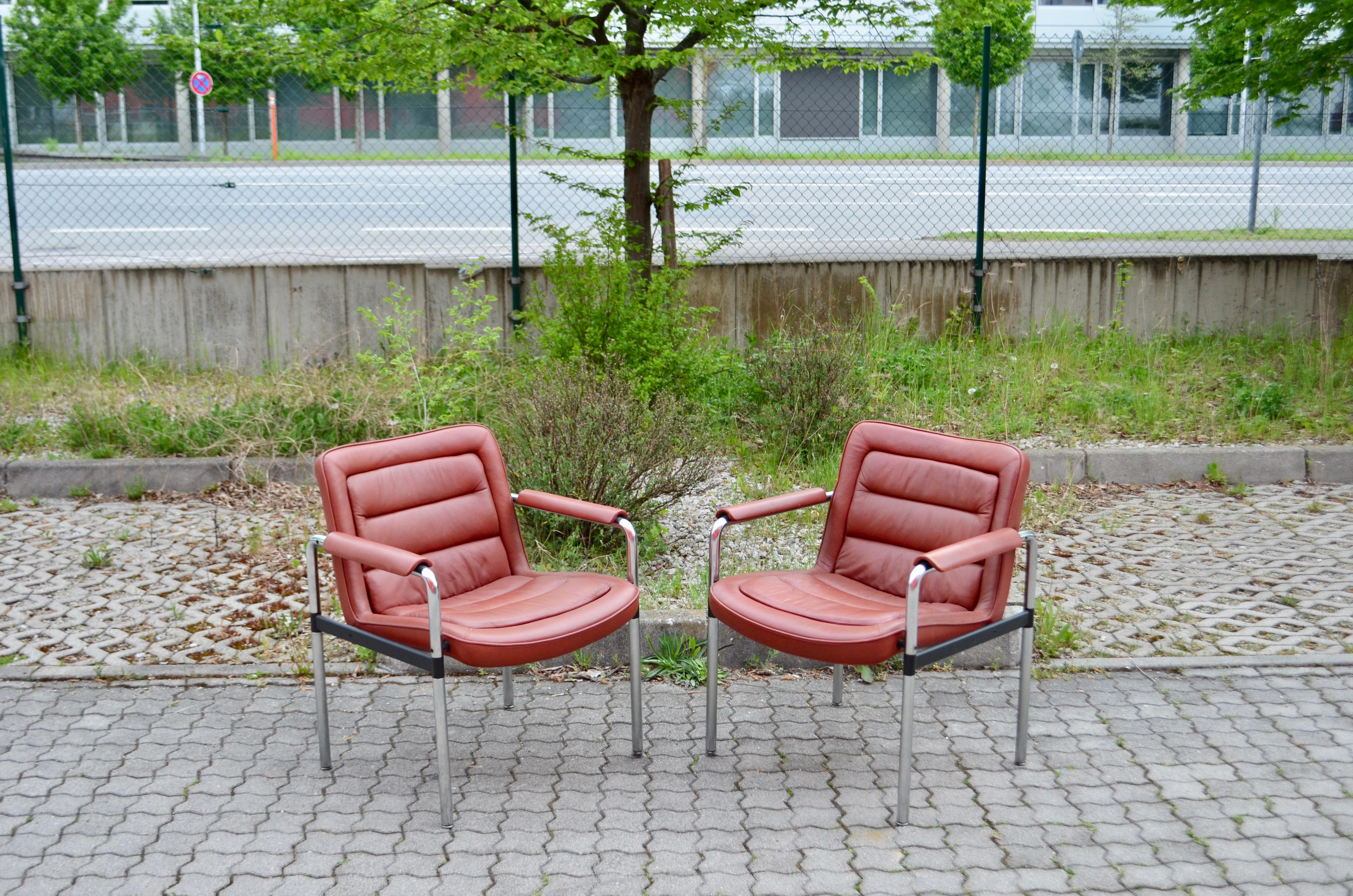 Ce fauteuil de la série 8400 a été conçu par Jorgen Kastholm pour Kusch + Co 
Les pièces comprennent des bases en acier tubulaire chromé mat et un revêtement en cuir rouge avec des accoudoirs.
Les accoudoirs sont bien patinés
Grand confort