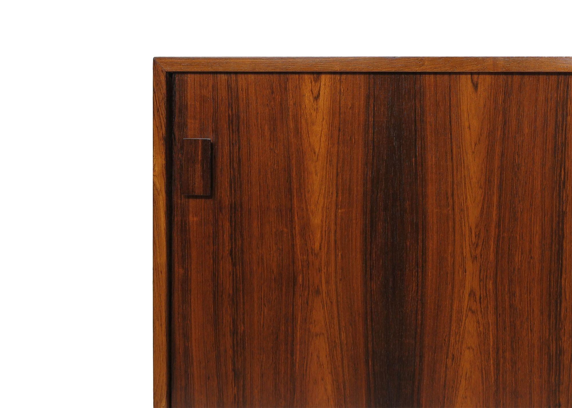 Mid-century Danish Brazilian Rosewood credenza designed by Jorgen Rasmussen for Dammann & Rasmussen Mobelfabrik, 1958, Denmark. The credenza is finely crafted of nicely figured Brazilian rosewood with mitered edges, book-matched grain, and squared