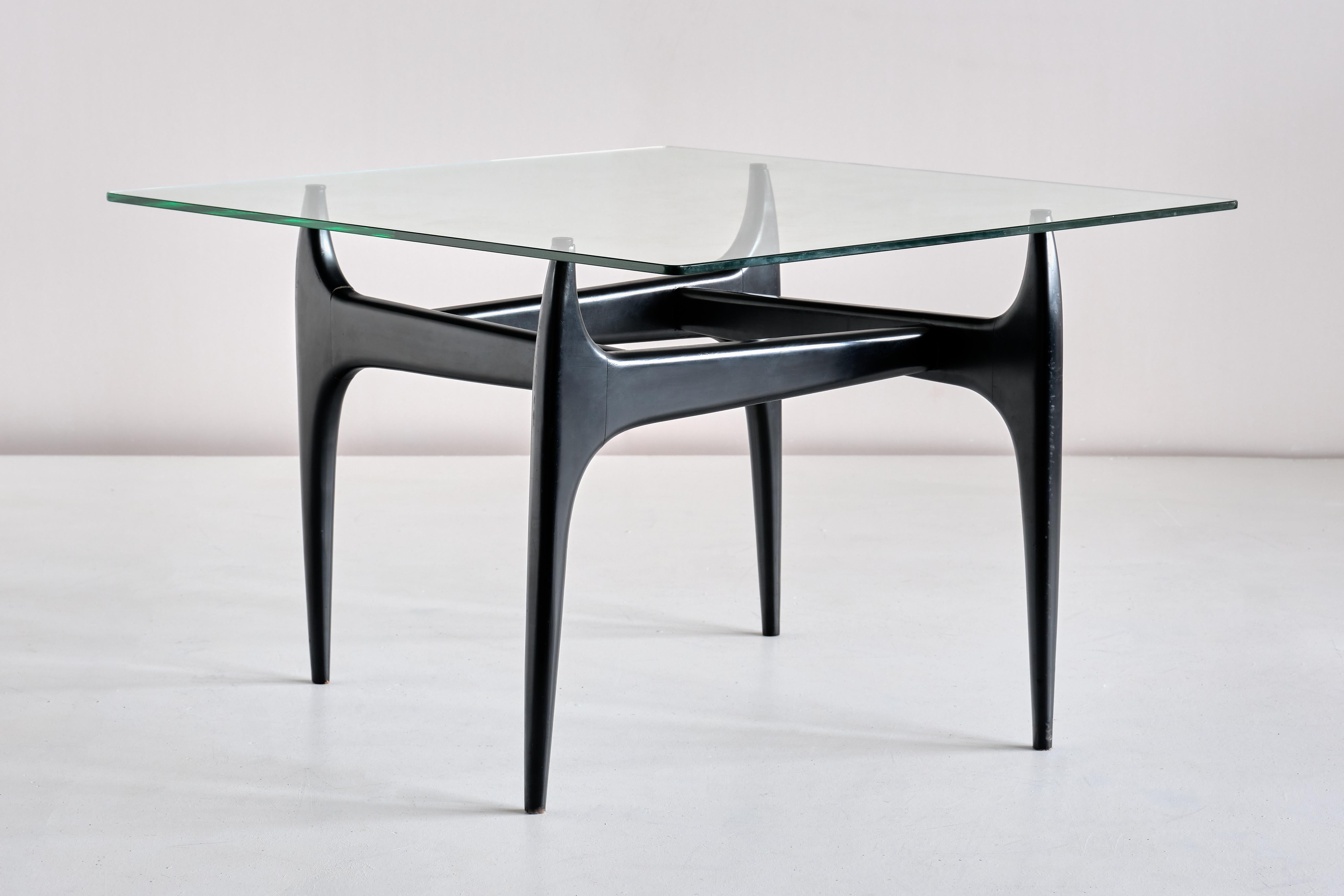 This very rare coffee table was designed by Jos De Mey and produced by the company Luxus in Kortrijk, Belgium in 1957. The elegant base is in black lacquered wood, with a square glass top resting on rubber caps. A refined design which is beautiful