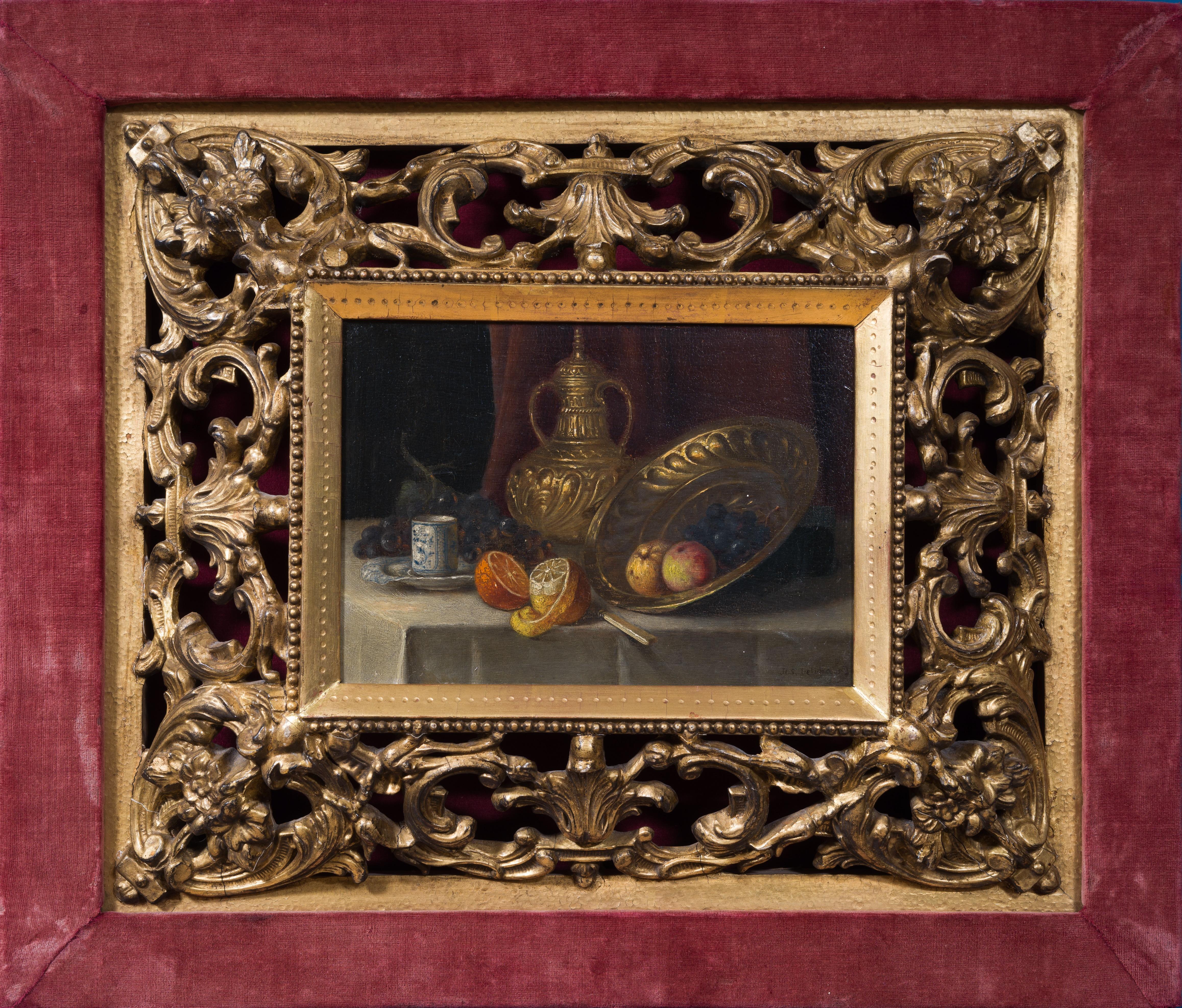 Housed in an elaborate late nineteenth-century carved gilt frame lined with deep red velvet, the painting offers a harmonious composition of carefully arranged objects illuminated by a soft, raking light. On a wooden table partially draped with a