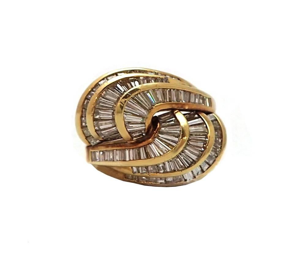 Make a statement with this 18kt yellow gold swirling Jose Hess designed cocktail ring featuring nearly a hundred baguette diamonds totaling 4.50ct. Its unique interlocking shape will make this piece the talk of any event! Signed and numbered by Jose