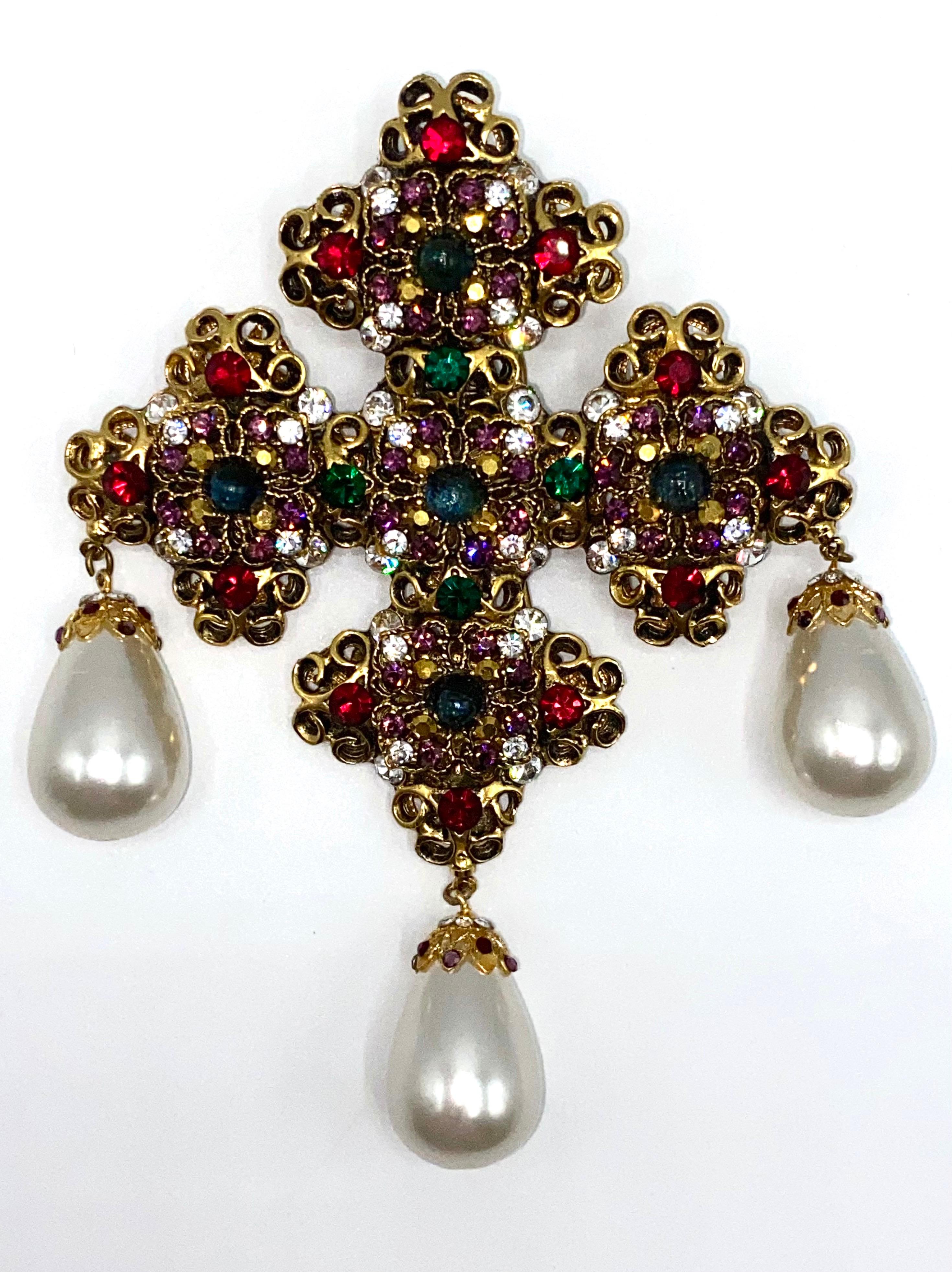 A rare and stunningly beautiful and regal heraldic Renaissance style cross brooch from the 1980s by American fashion jewelry designers Jose & Maria Barrera. The The body of the cross is made of gold plate openwork medallions and filled with an amber