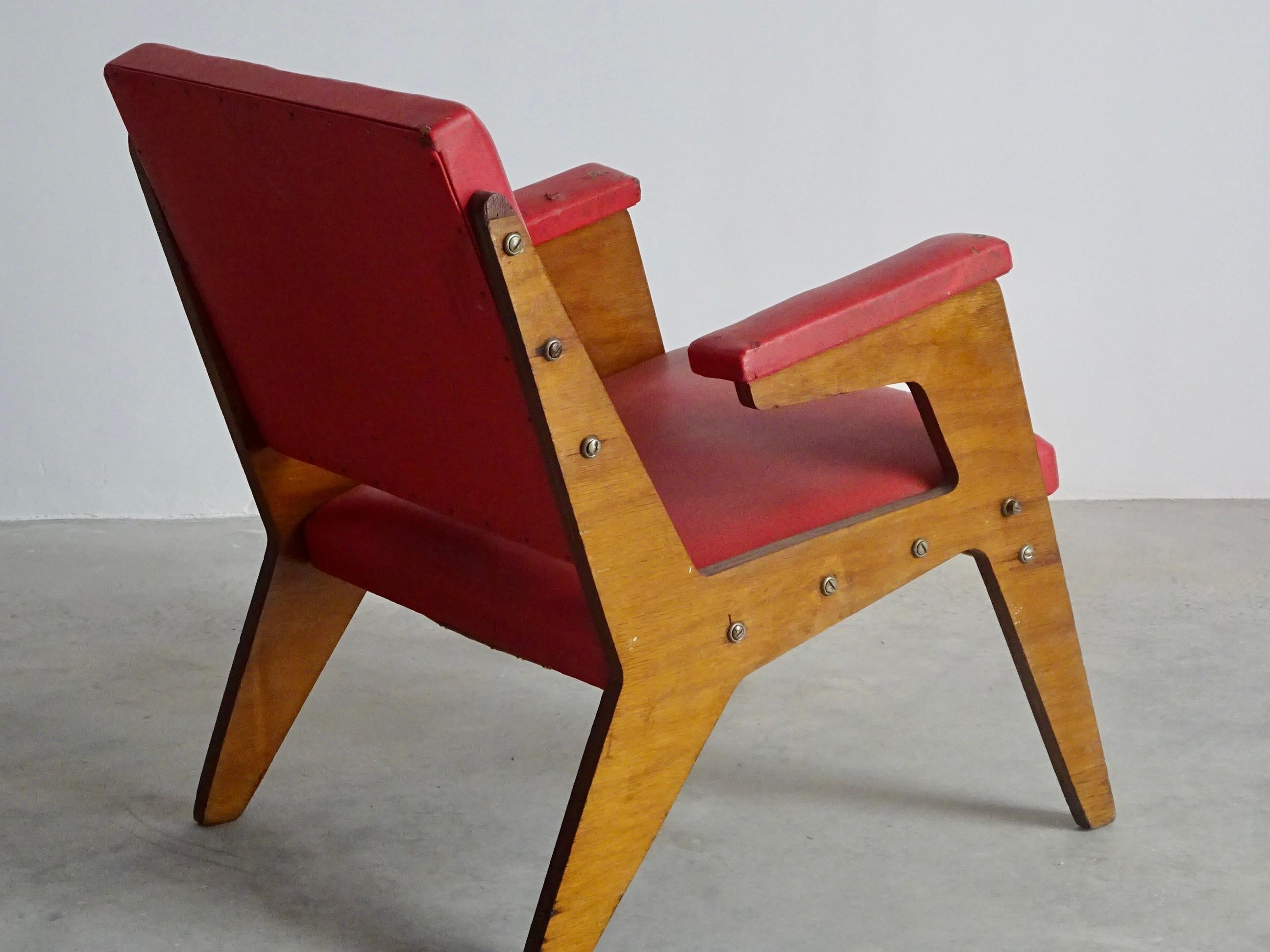 Armchair designed by José Zanine Caldas, produced by “Móveis Artísticos Z” in São Paulo (Brazil), 1950’s. Original condition, strong plywood structure with the usual wear and tear of time, red upholstery with some small tears, screws are the