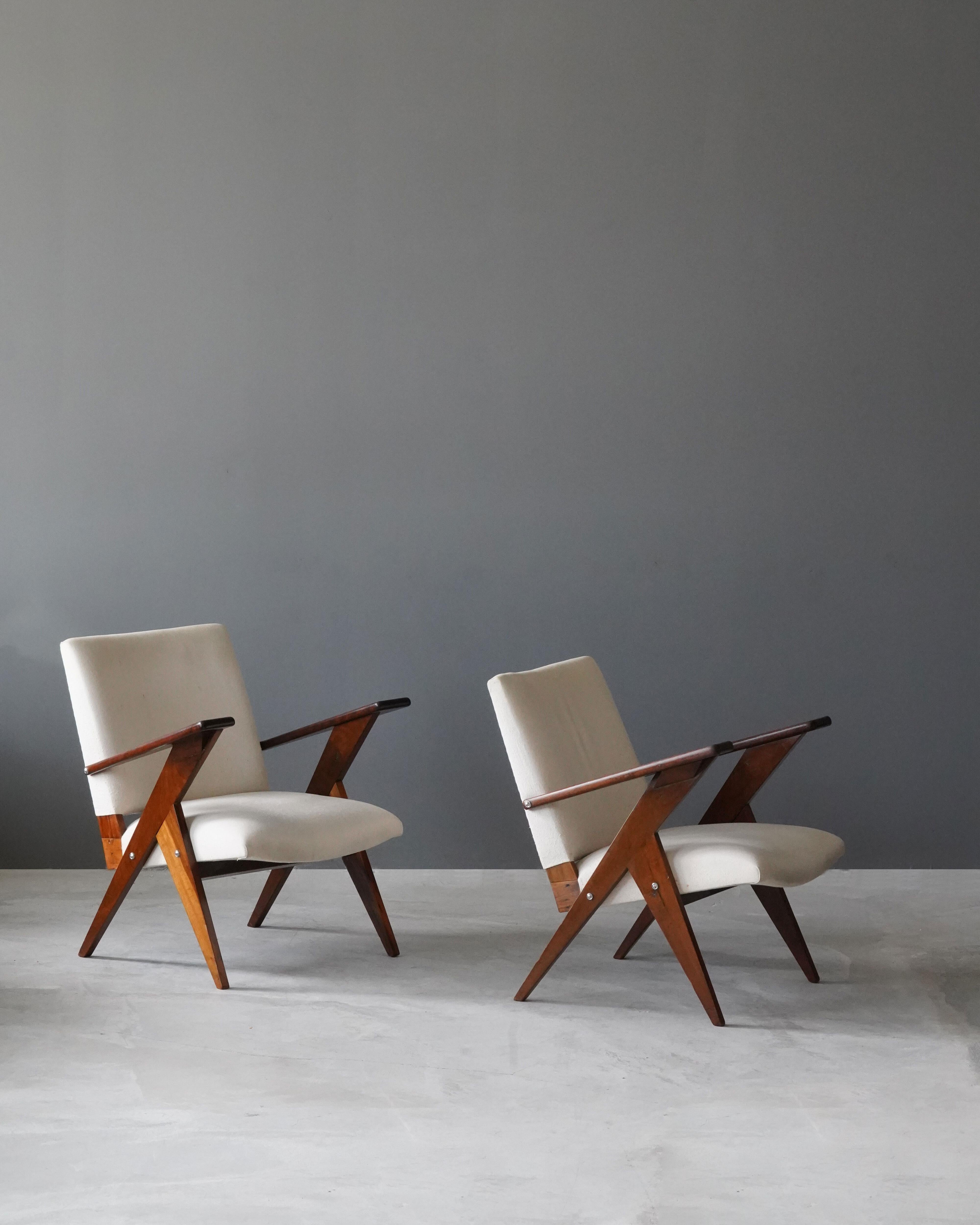 A pair of lounge chairs / armchairs. Designed by José Zanine Caldas, produced by Mòveis Artisticos Z, Brazil, 1950s.

In Imbuia wood, in white fabric. 

Other designers of the period include Joaquim Tenreiro, Jorge Zalszupin, Luis Barragan,