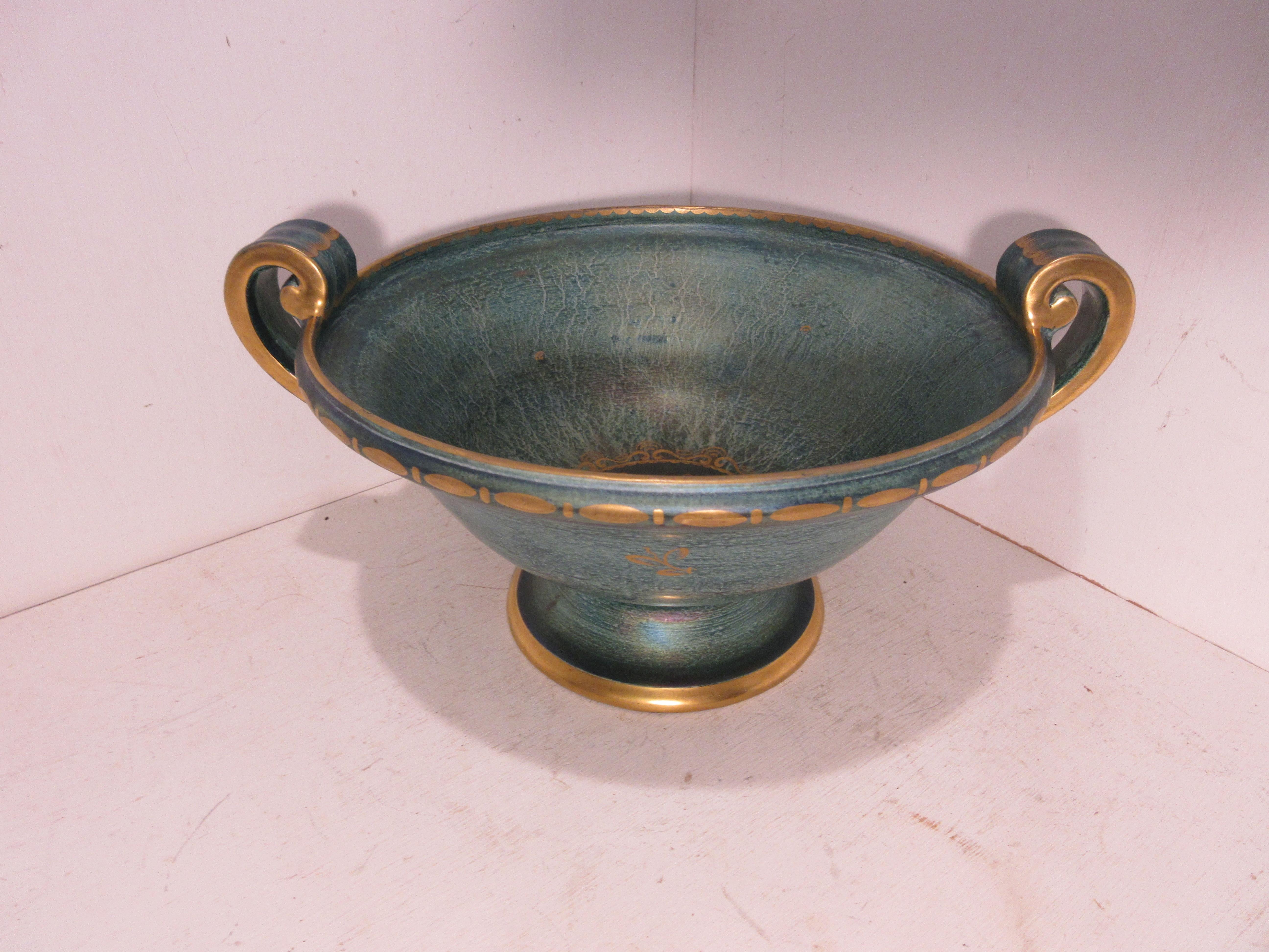 This is a handmade rare Swedish Art Deco ceramic bowl in green and gold luster glaze hand decorated with gold made by the Swedish ceramic artist Josef Ekberg. He was one of Sweden’s top ceramic artist at the time. He started working at the
