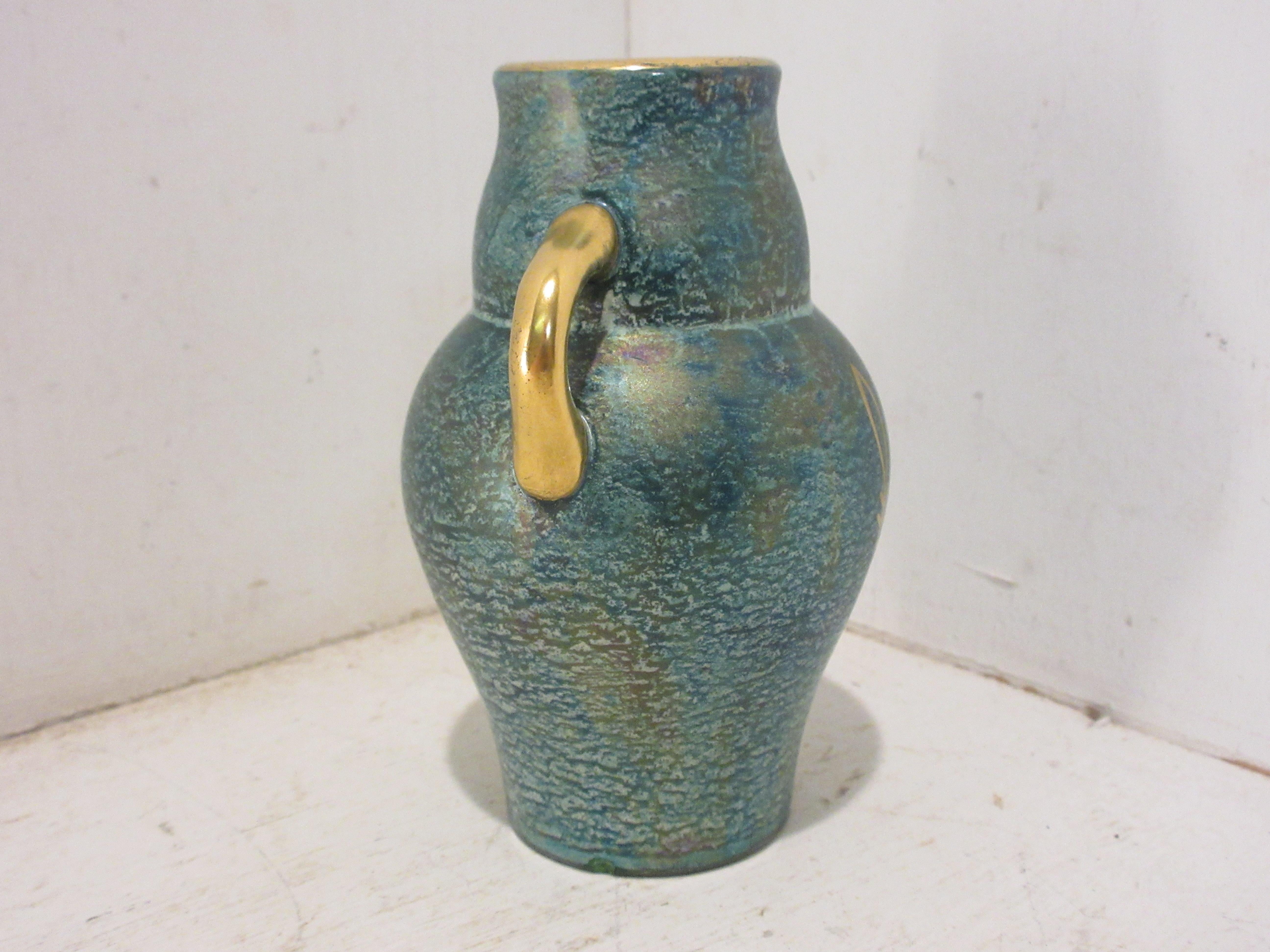 This is a handmade rare Swedish Art Deco ceramic jar in green and gold luster glaze hand decorated with gold made by the Swedish ceramic artist Josef Ekberg. He was one of Sweden's Top Ceramic artist at the time. He started working at the