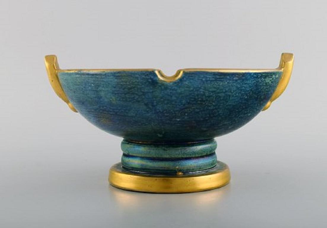 Josef Ekberg for Gustavsberg. Art Deco bowl in glazed ceramics.
Beautiful blue-green glaze and gold decoration,
1930s.
Measures: 21.5 x 11 cm.
In excellent condition.
Stamped.