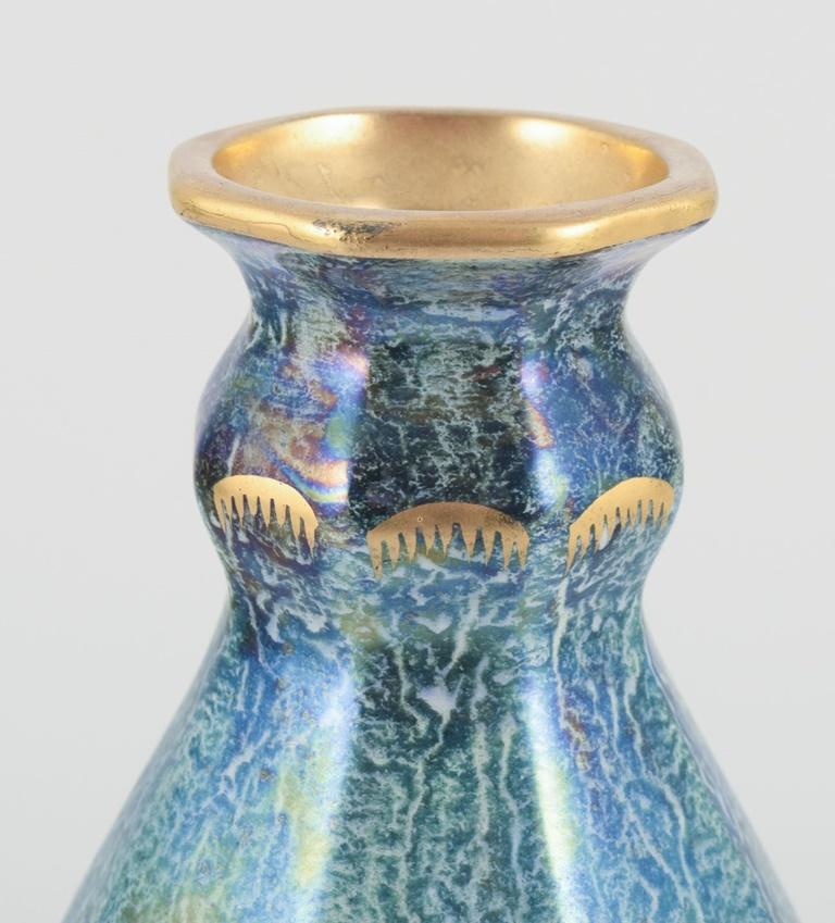 Gebrauchte Waren sind für US-Kunden von den Einfuhrzöllen befreit. 
Daher fallen für Ihren Kauf keine Einfuhrzölle an.

Josef Ekberg für Gustavsberg.
Achteckige Vase aus Kunstkeramik. Handbemalt mit Lüsterglasur und Golddekor.
Grün-blaue