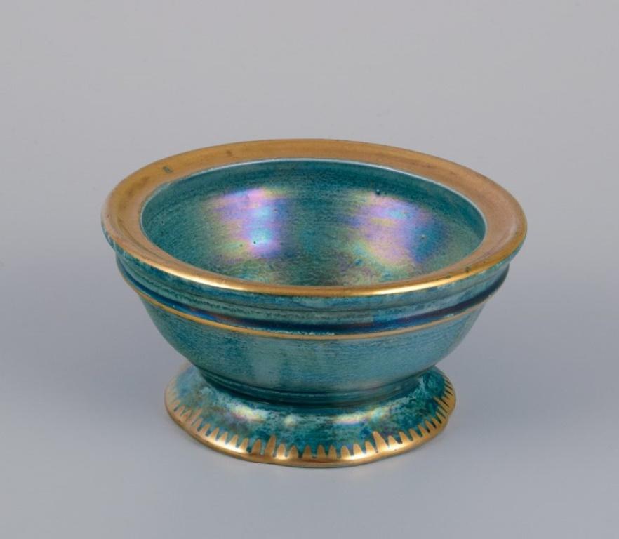 Josef Ekberg for Gustavsberg, Sweden.
A pair of candle holders and a small bowl in ceramic. 
Glaze in blue-green tones with a gold rim.
Mid-20th century.
Marked.
In perfect condition.
Candle holders: Diameter 9.0 cm x Height 6.5 cm.
Small bowl: