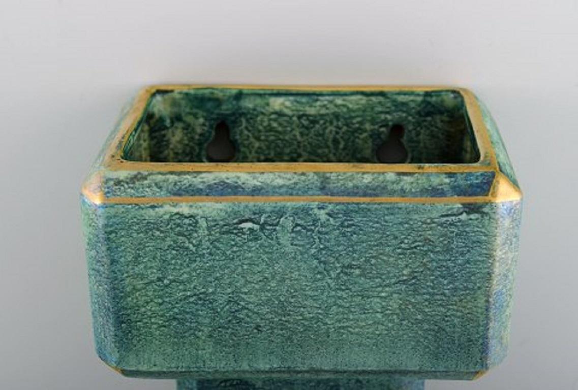 Josef Ekberg for Gustavsberg. Rare Art Deco flower pot cover in glazed ceramics. Beautiful blue-green glaze and gold decoration, 1930s.
Measures: 13 x 10.5 cm.
In excellent condition.
Stamped.