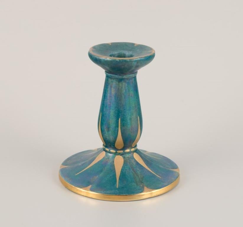 Josef Ekberg (1877-1945) for Gustavsberg, Sweden. 
A pair of candle holders with glaze in green-blue tones, gold decoration.
Mid-20th century.
Marked.
In perfect condition.
Dimensions: Diameter 12.5 cm x Height 13.5 cm.