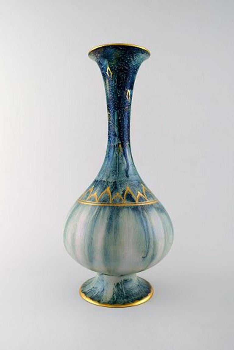 Josef Ekberg, Gustavsberg, large vase with narrow neck. Blue-green glaze with gold decoration.
Measures 35 cm. x 17 cm.
In perfect condition.
Stamped.