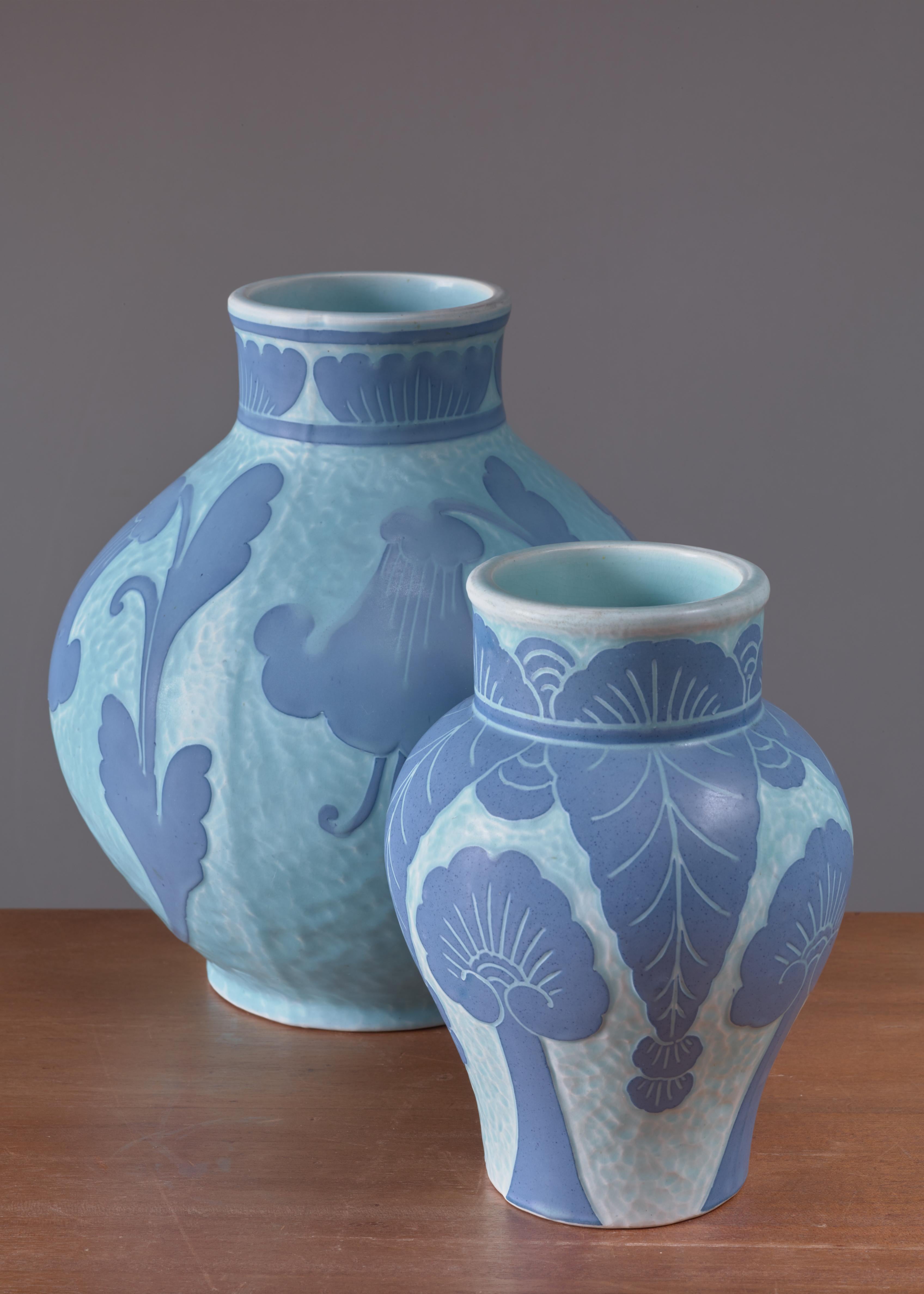 A pair of blue ceramic 'Sgraffito' vases, decorated with a floral motif, by Josef Ekberg for Gustavsberg. 
The measurements stated are of the largest vase. The other vase is 21 cm (8 inch) high and has a 14 cm (5.5 inch) diameter.

Both vases are