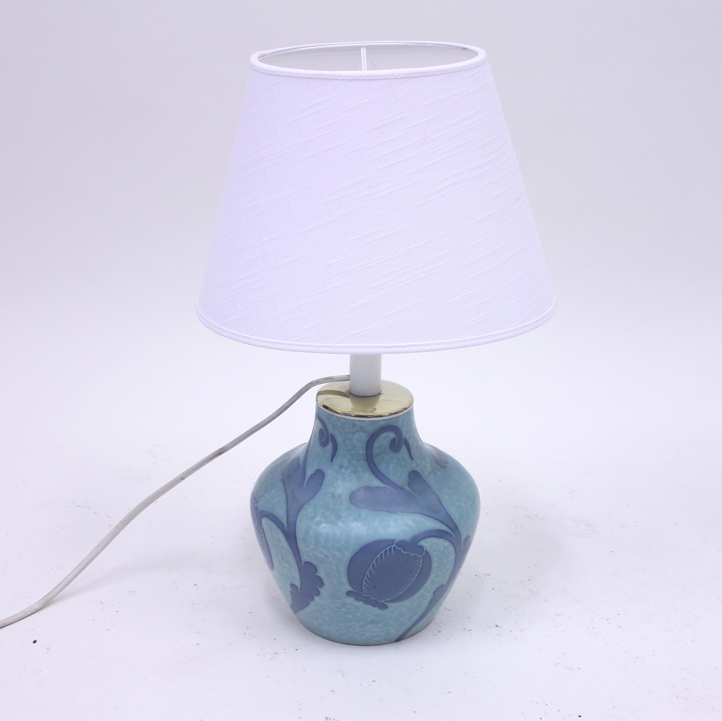 Sgrafitto table lamp in light blue stoneware decorated with dark blue flower motifs and brass light fitting, designed by Swedish ceramicist Josef Ekberg for Gustavsberg in 1923. Very good condition with minimal ware. Later white shade. Marked JE,