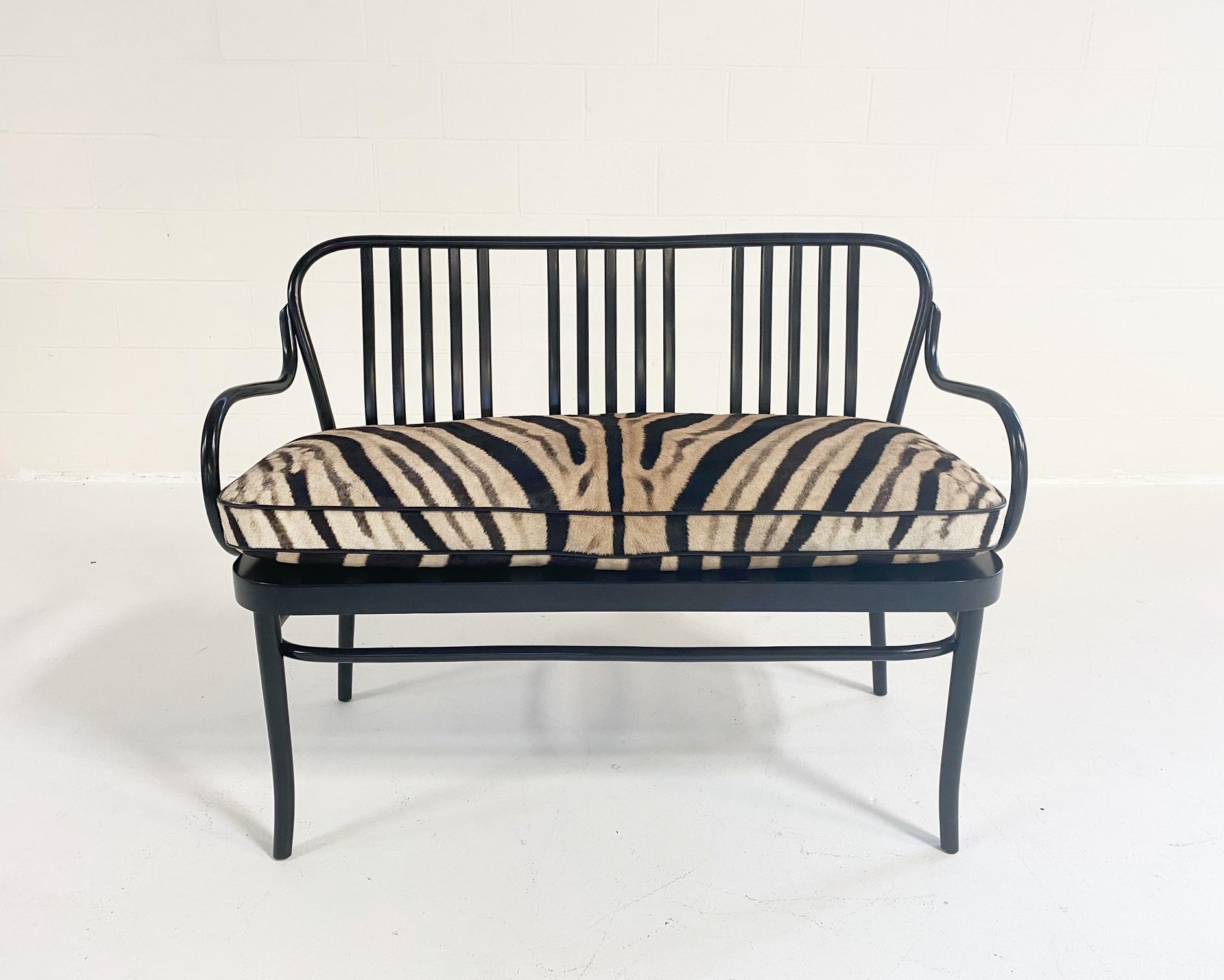 Wow factor! A Classic Thonet frame with an elevated luxury look. The slick, bentwood, black-lacquered frame is the perfect base for a custom, feather-filled zebra hide cushion. The cushion is finished with a cool black leather welt and ties. Beauty