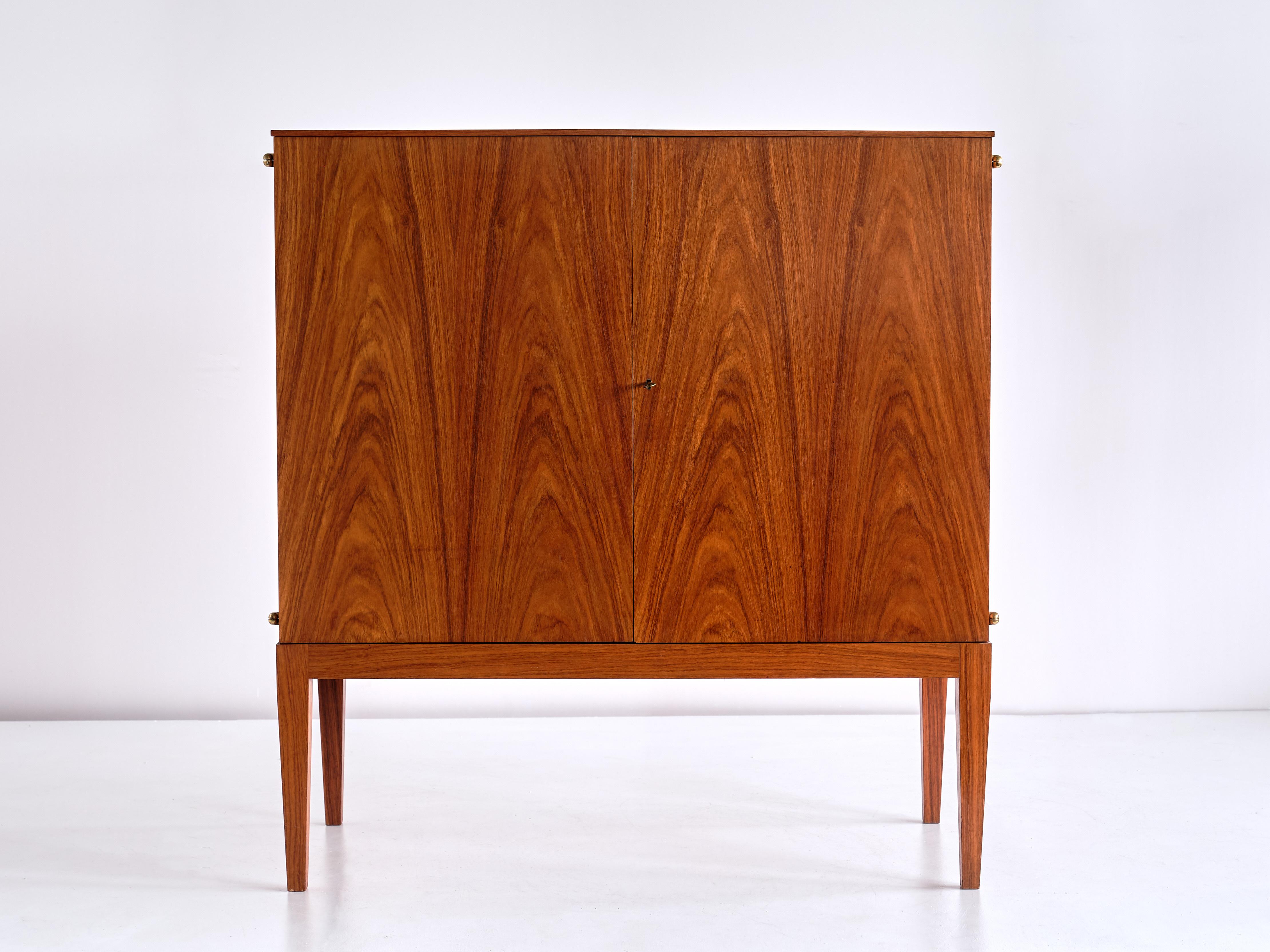 This elegant rosewood cabinet was designed by Josef Frank for Svenskt Tenn in the late 1930's. In the Svensk Tenn archive's furniture book, Estrid Ericson (the founder of Svenskt Tenn) has made a pencil sketch of the cabinet and written 