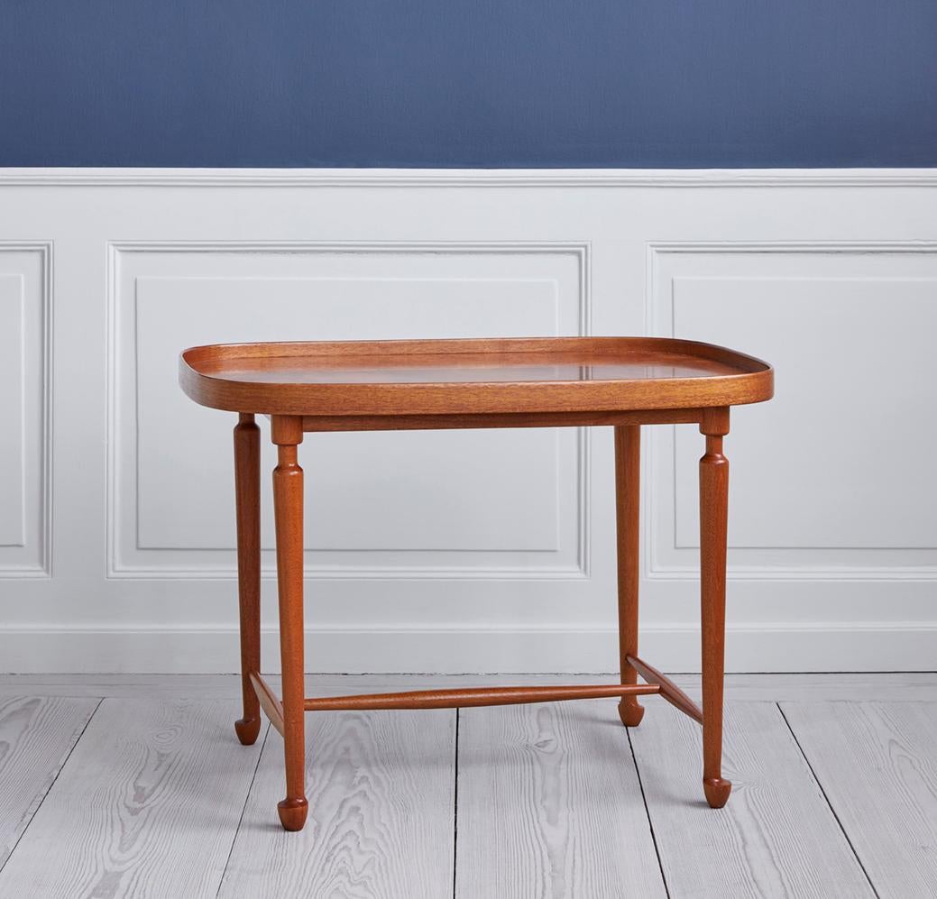 Elegant mahogany tea table “Tebordet” model 974 with rounded edges and curved details. Designed by Josef Frank for Svenskt Tenn in the 1950s.
  