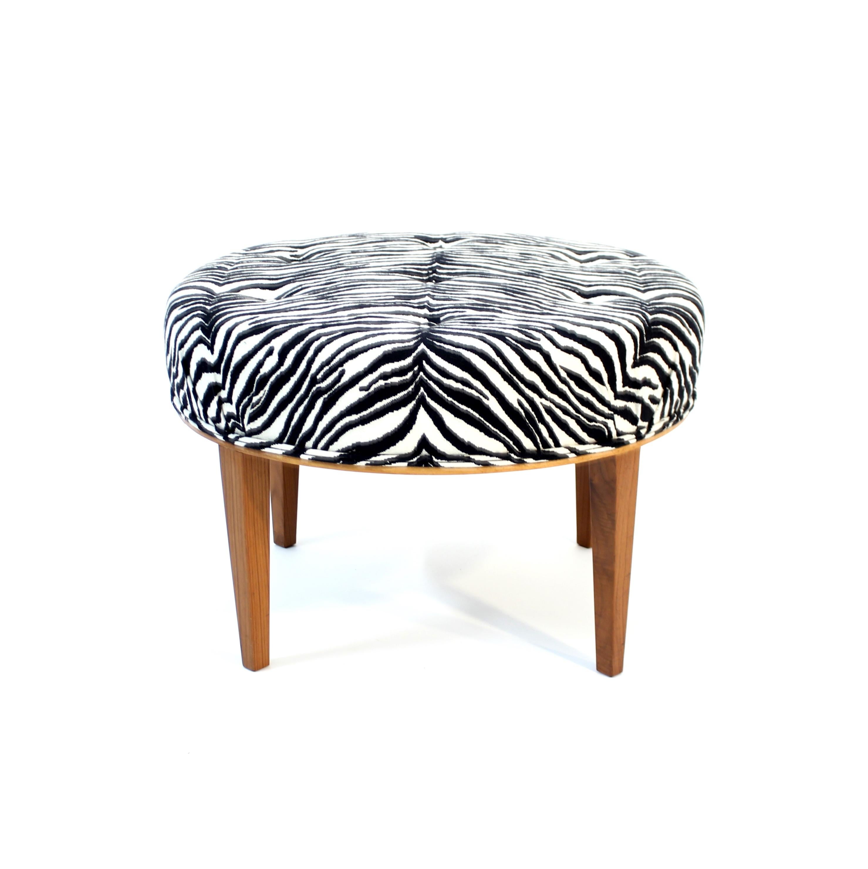 Stool or foot stoll designed by Josef Frank in 1936 for Svenskt Tenn. This example dates back to the late 1970s and was originally ordered by a hotel in Uppsala, Sweden. Legs made of Walnut and the seat is newly reupholstered with a Zebra patterned