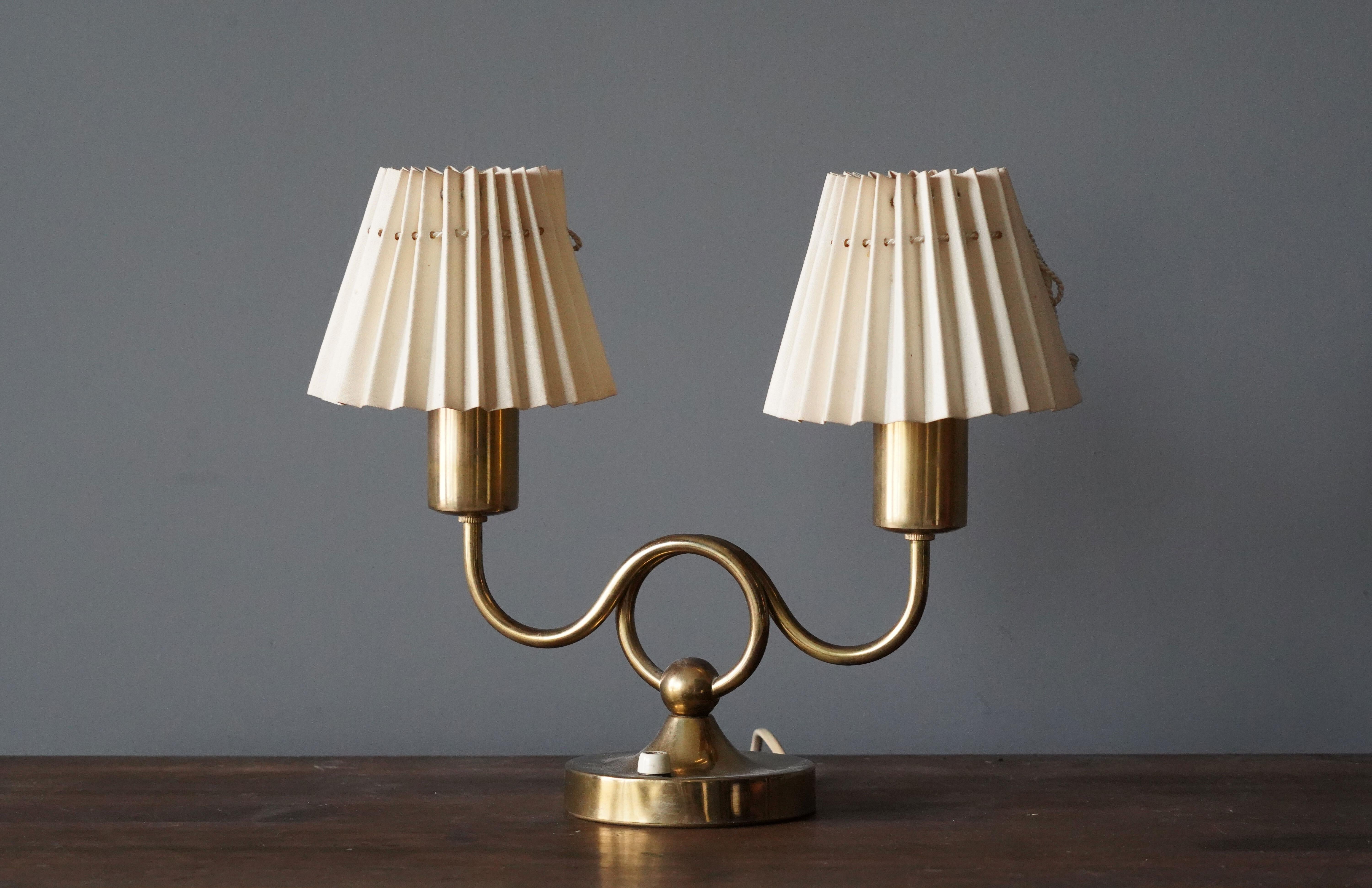 An early production table lamp by Josef Frank for Svenskt Tenn, Stockholm, Sweden. 

With brass and original paper shades.

Other lighting designers of the period include Paavo Tynell, Alvar Aalto, Serge Muille, and Angelo Lelii.