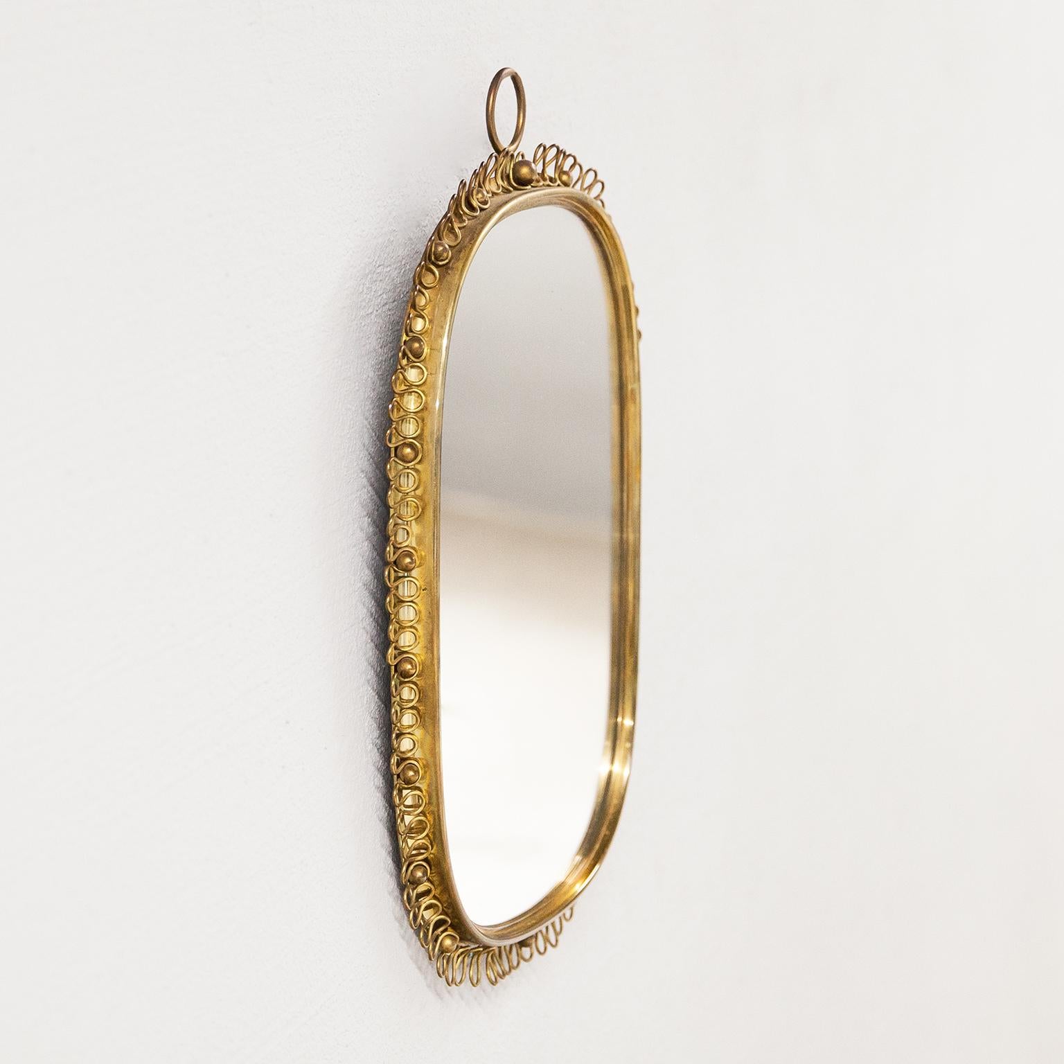 A beautiful mirror with a nice oval brass frame and a decorative brass ring from the 1950s. Designed by Josef Frank for Svenskt Tenn, Sweden.