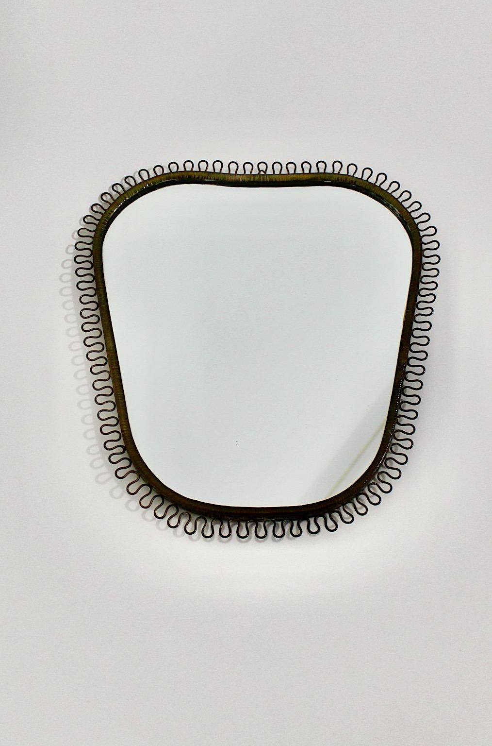 Josef Frank vintage loop wall mirror heart like for Svenskt Tenn 1950s Sweden.
The wall mirror shows cute solid brass loops at the frame heart like shape partly blackened through the age, the mirror glass shows nice mirror patina as well.
Backside