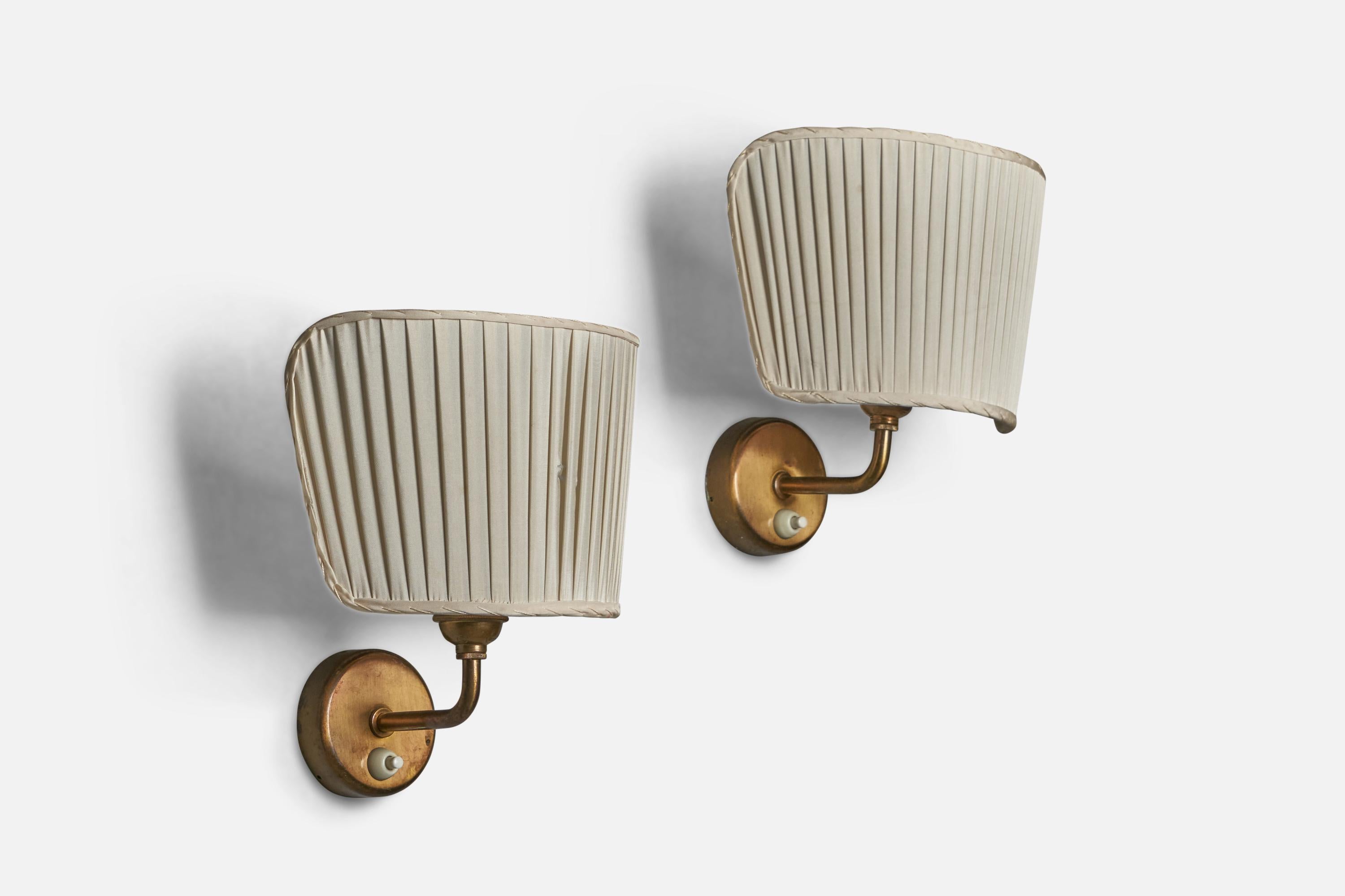 A pair of brass and white fabric wall lights designed by Josef Frank and produced by Svenskt Tenn, Sweden, c. 1950s.

Overall Dimensions (inches): 9” H x 8.25” W x 6.5” D
Back Plate Dimensions (inches): 3.95” Diameter
Bulb Specifications: E-26